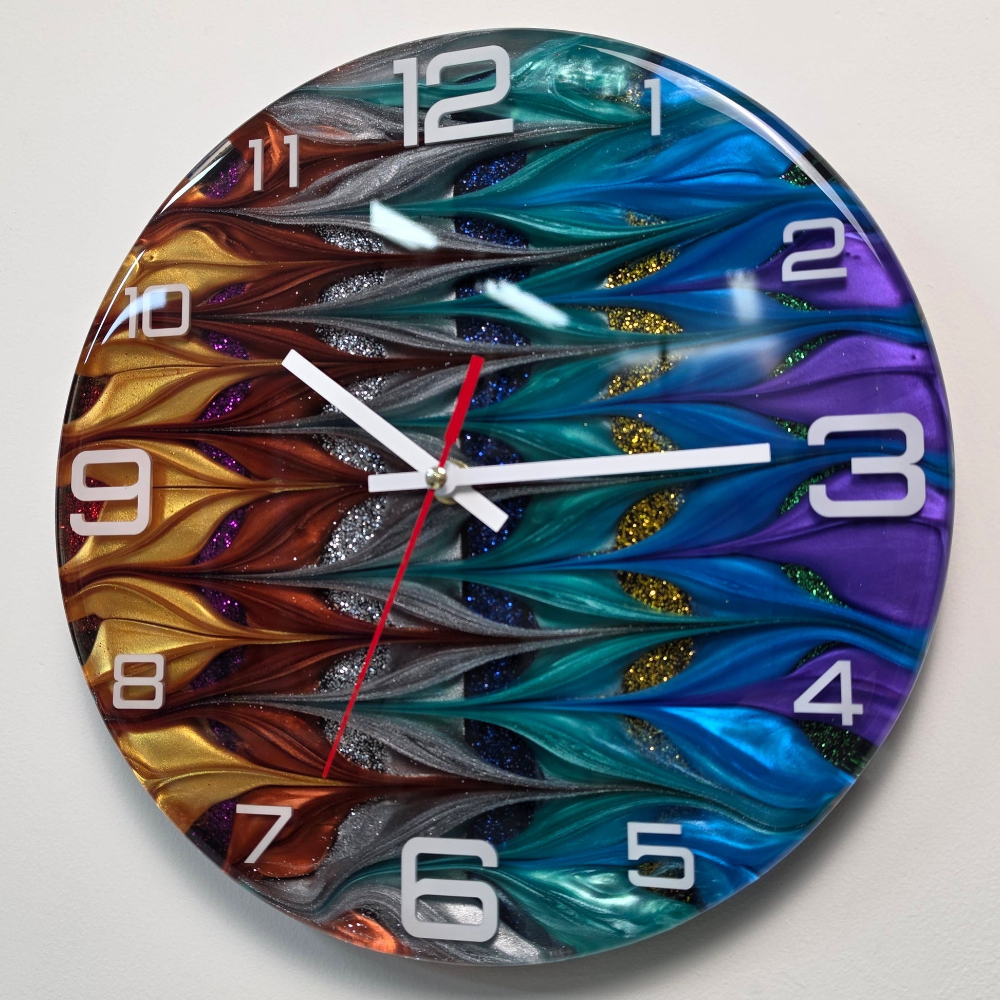 Unique abstract resin wall clock with flowing metallic colors, white acrylic numerals and contemporary design