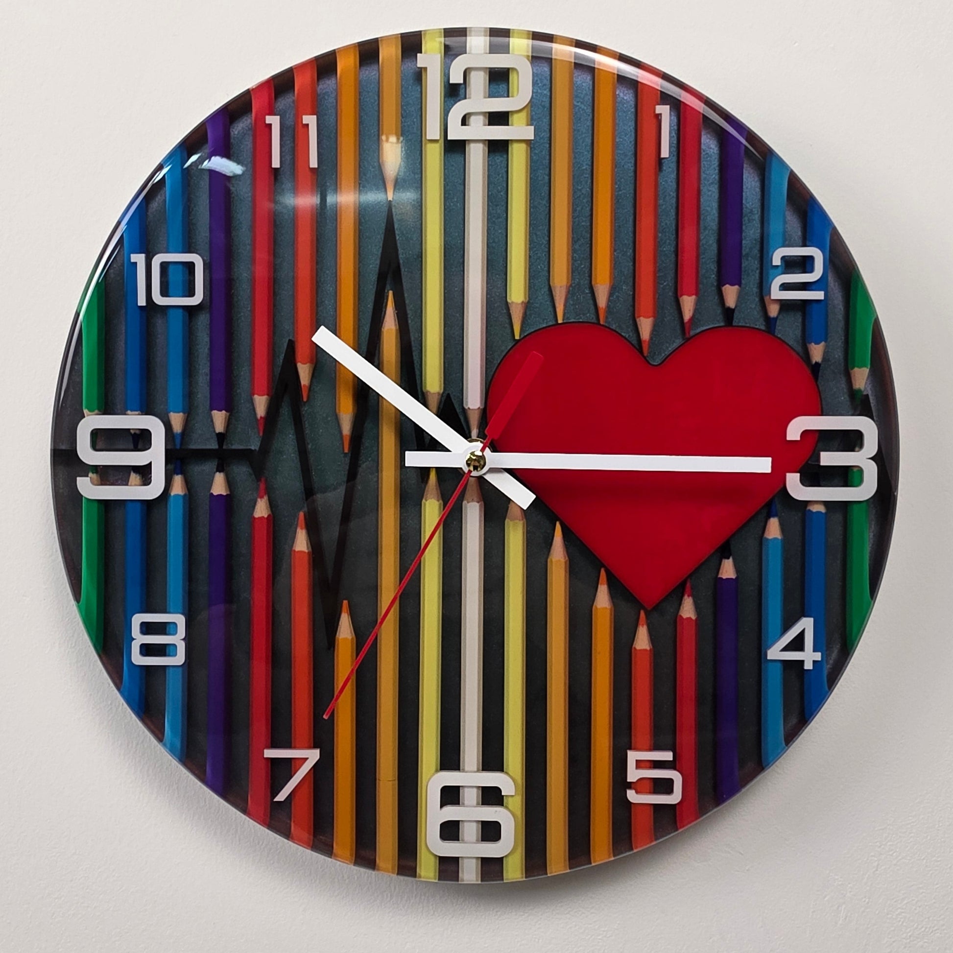 One-of-a-kind decorative wall clock with a vibrant pencil design, red heart centerpiece, epoxy resin finish, and original color-blending technique.