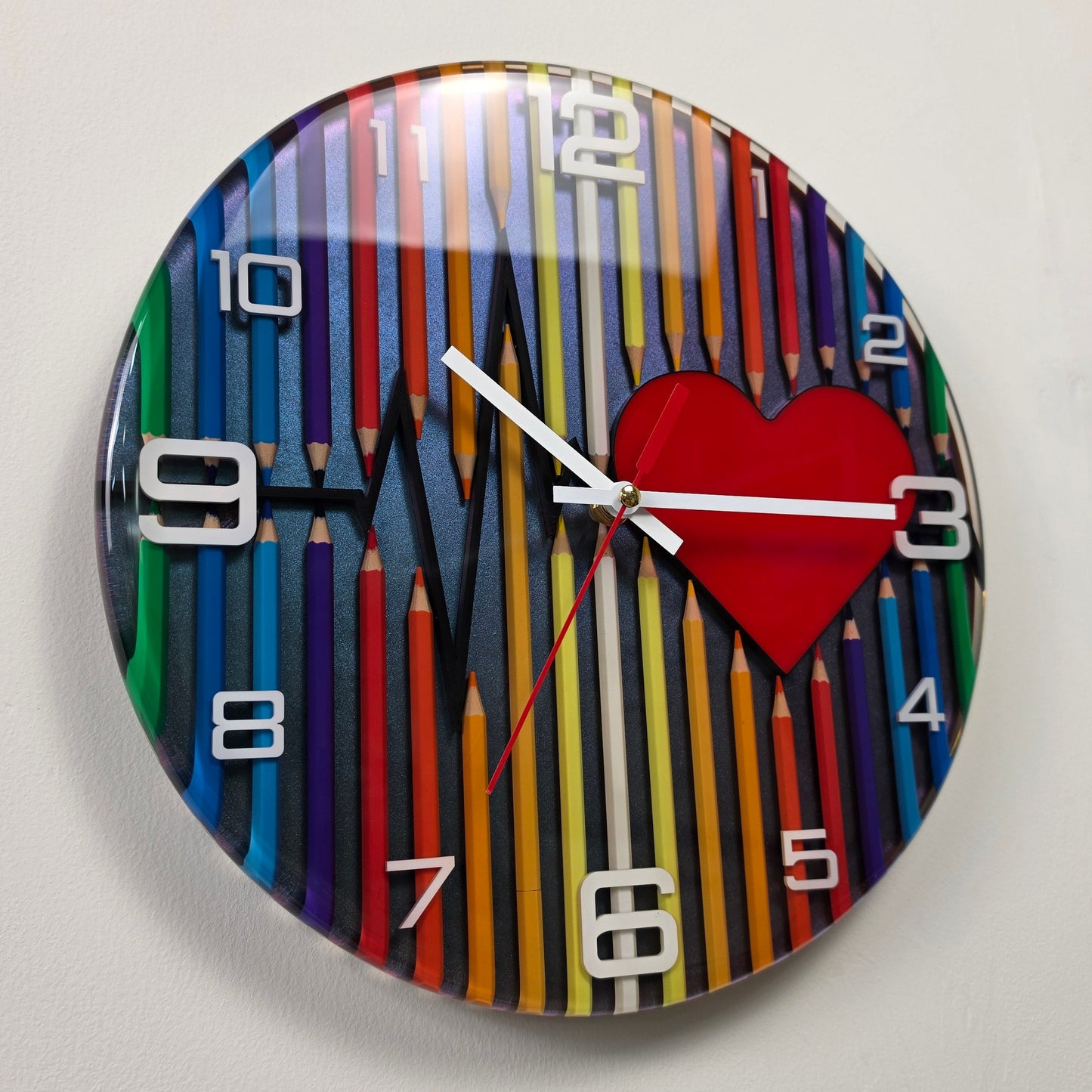 Contemporary handcrafted resin clock inspired by art, creativity, and emotion, featuring colorful pencils, a heartbeat line, and premium white acrylic numbers.
