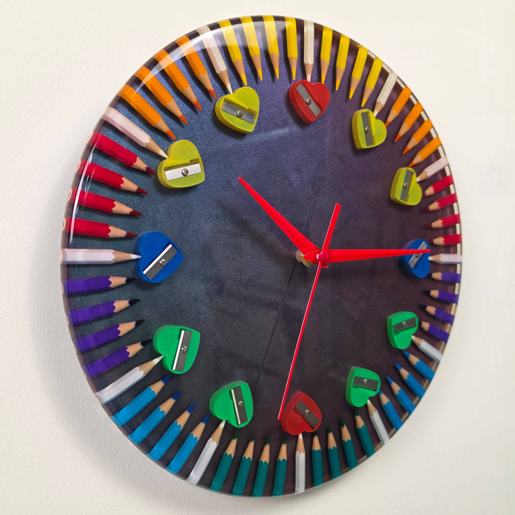 Designer epoxy resin clock with vibrant colored pencils, metallic chameleon finish, and silent quartz movement.