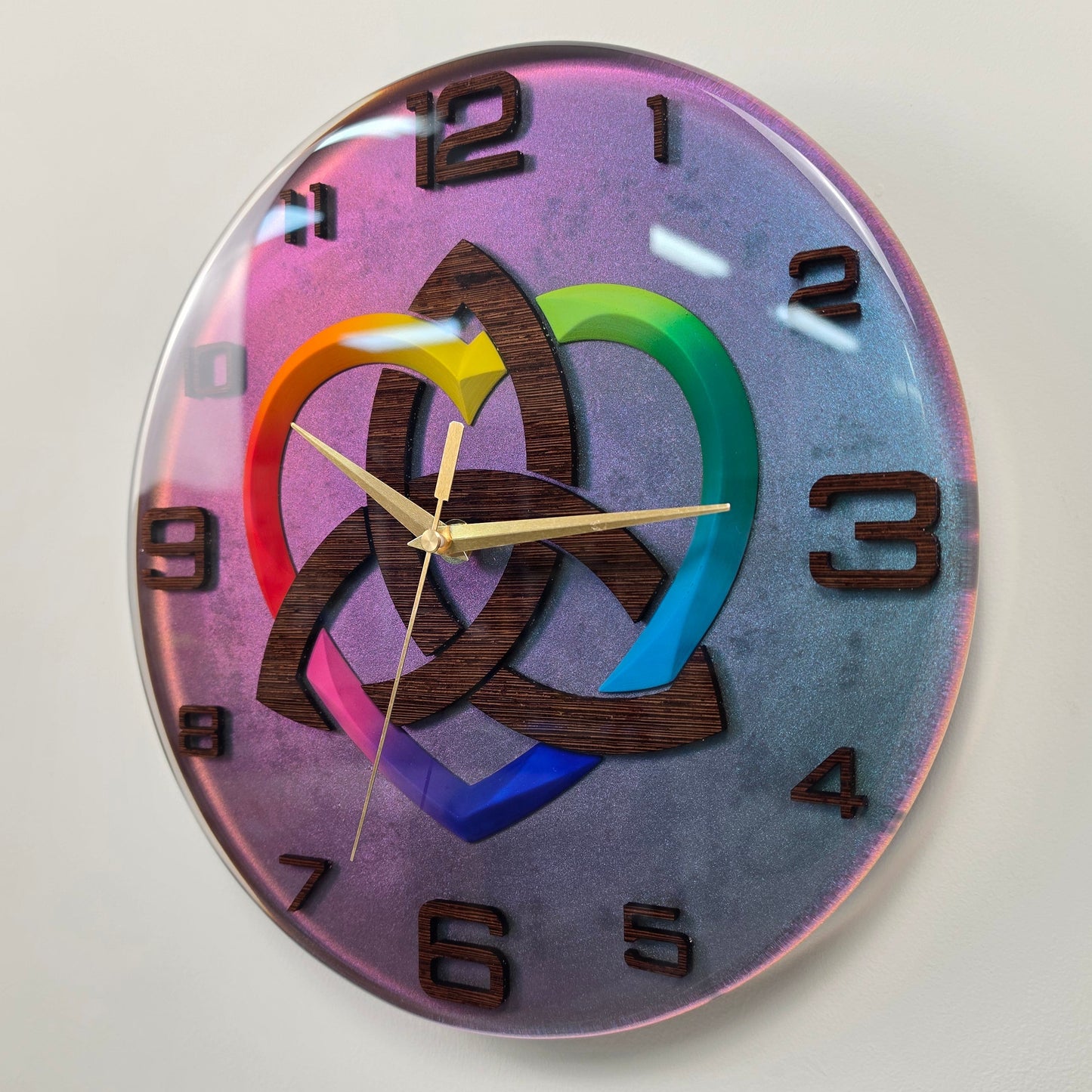 Contemporary handmade wall clock with a symbolic Triquetra design, rainbow heart, wenge wood numbers, and premium epoxy resin craftsmanship.