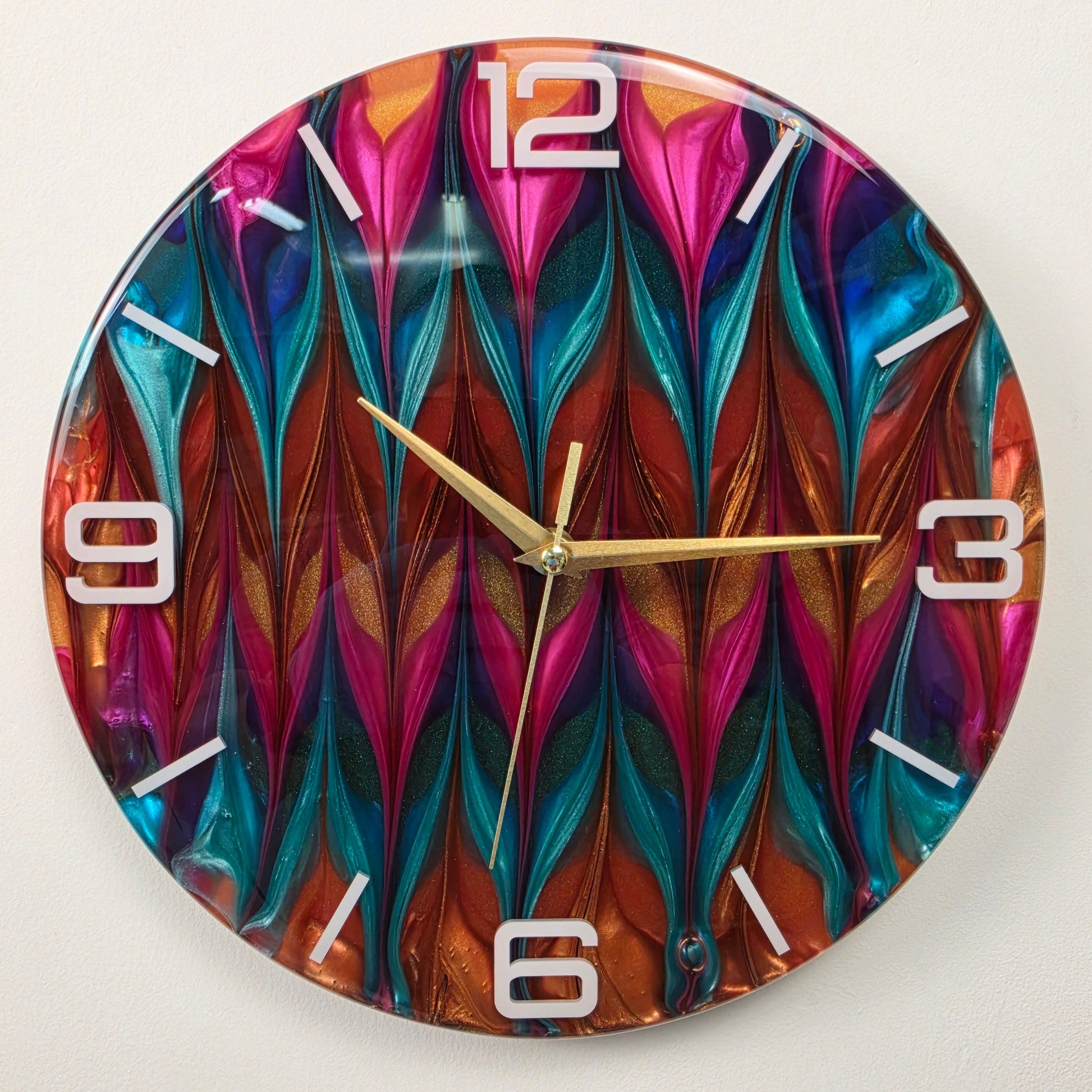 Handmade modern wall clock with layered metallic pigments, white hour markers and a glossy transparent resin finish.