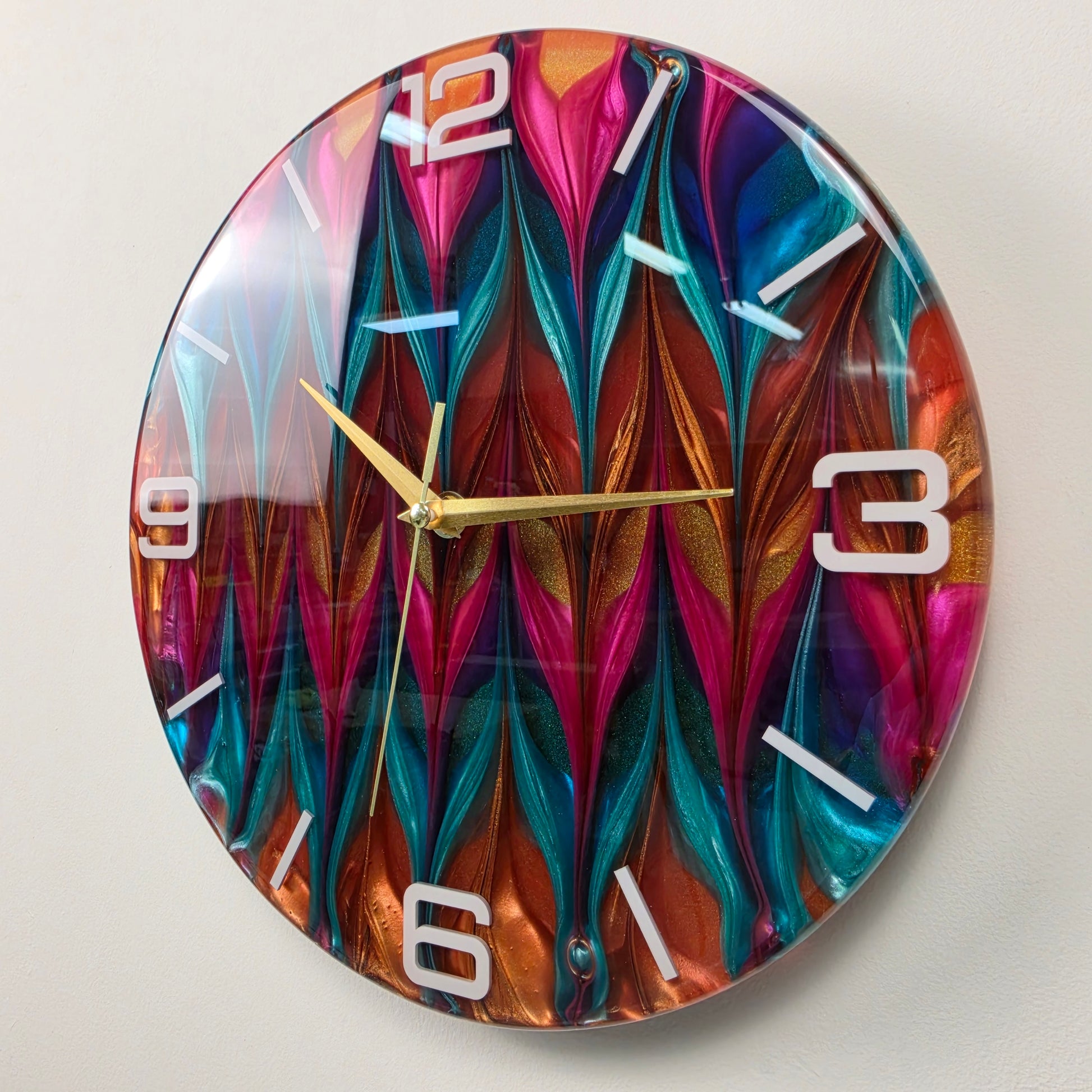 One-of-a-kind resin wall clock with a repeating turquoise, pink and copper abstract pattern and elegant gold hands.