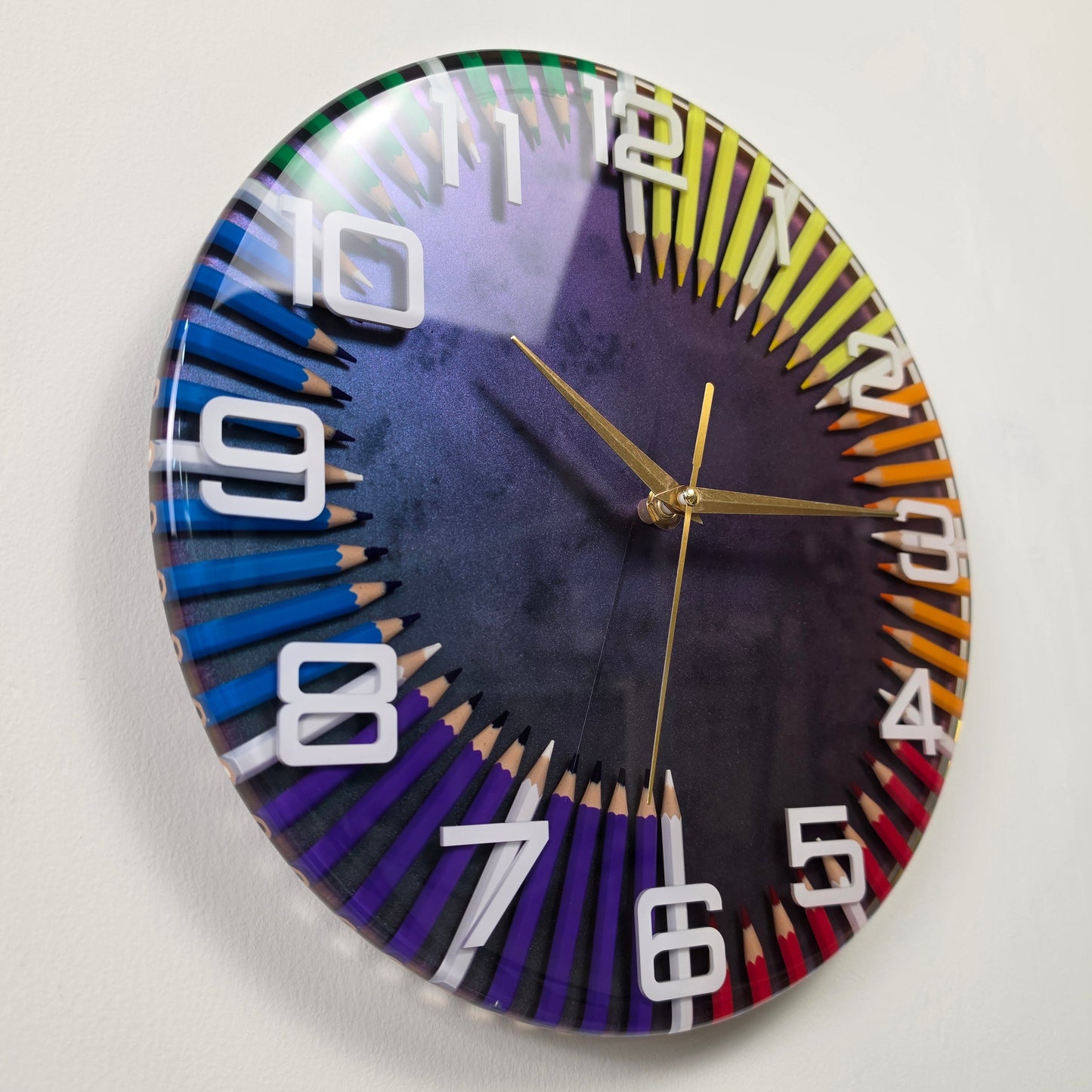 Handcrafted artistic wall clock featuring rainbow colored pencils arranged in a circular pattern