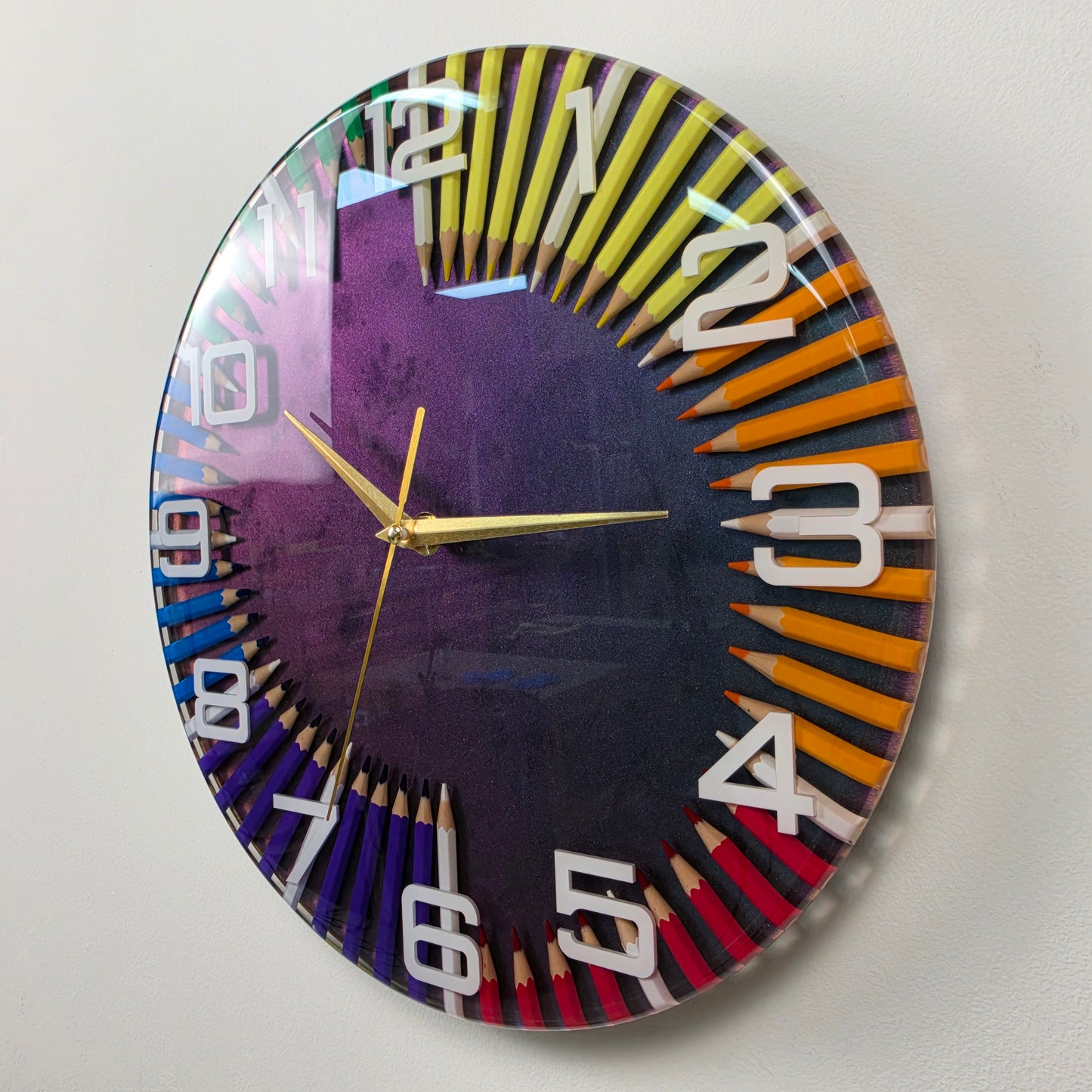 Studio Colors decorative wall clock with rainbow pencils embedded in glossy transparent resin