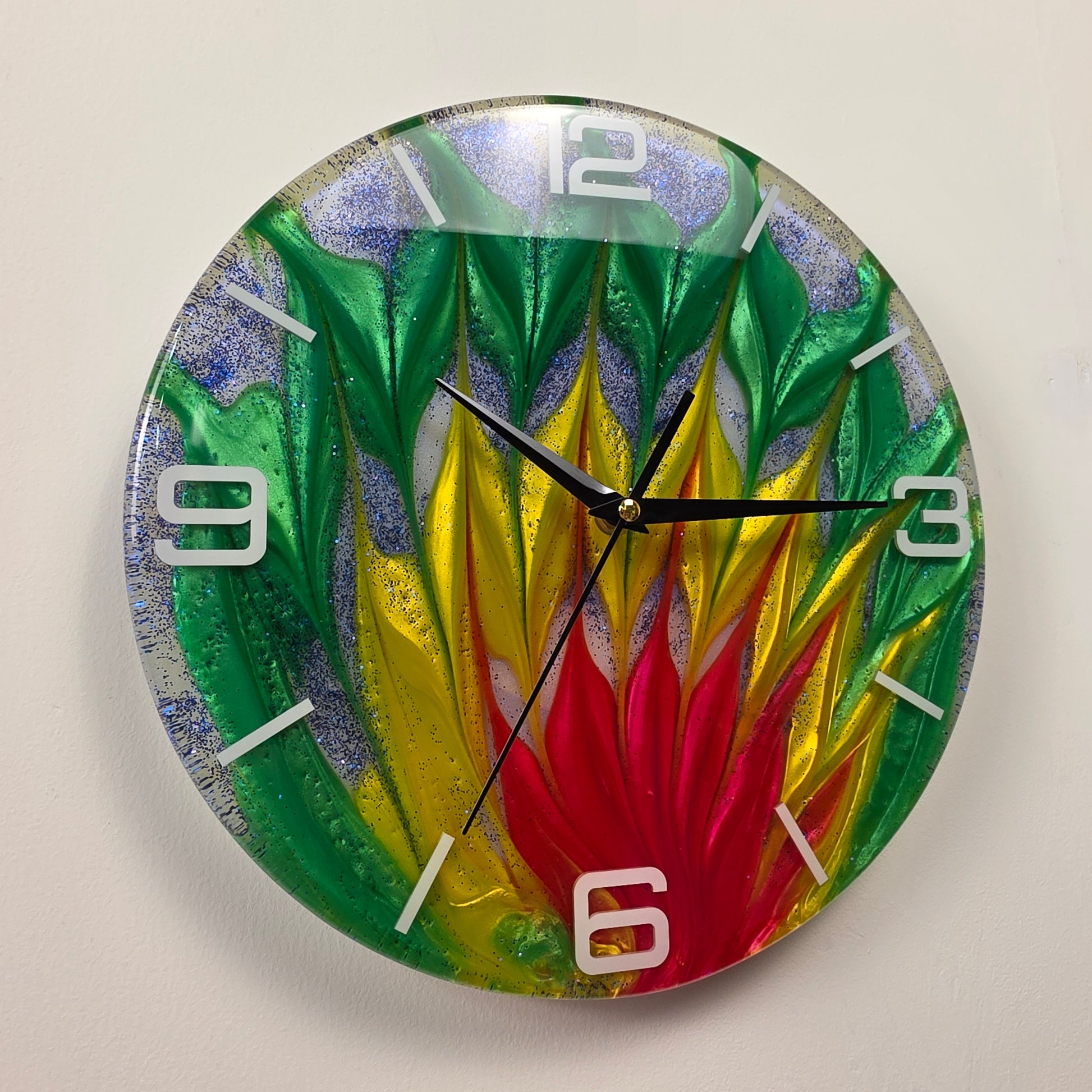 Handcrafted epoxy resin wall clock with vibrant green, gold, and red color-blended design, white acrylic numbers, and shimmering blue glitter from the Abstract Time collection.