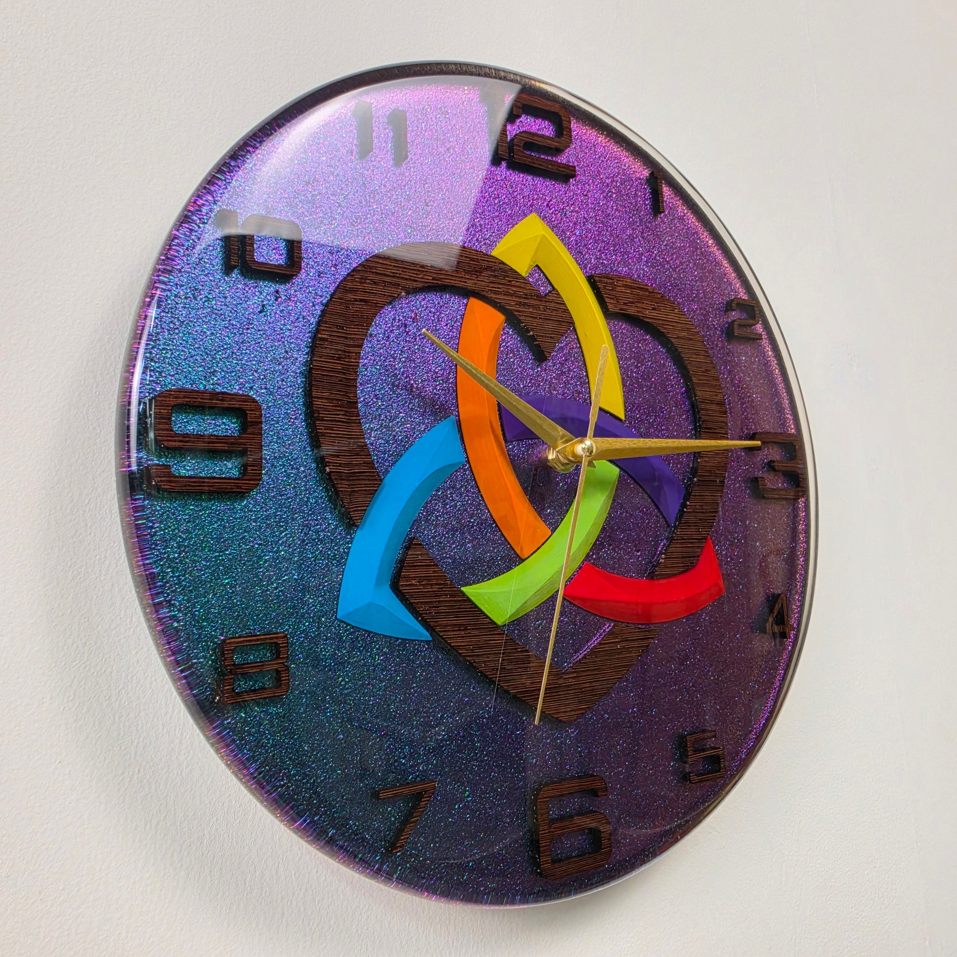 Contemporary handmade wall clock with a symbolic Triquetra design V2, rainbow heart, wenge wood numbers, and premium epoxy resin craftsmanship.