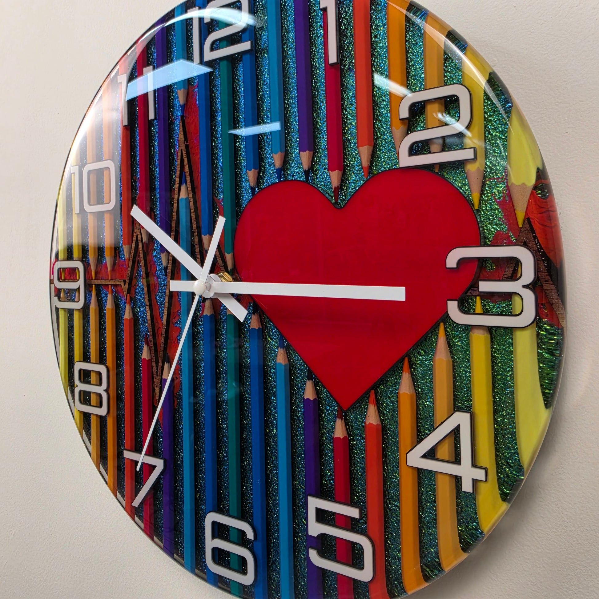 One-of-a-kind decorative wall clock with a vibrant pencil design, red heart centerpiece, epoxy resin finish, and original color-blending technique. V2