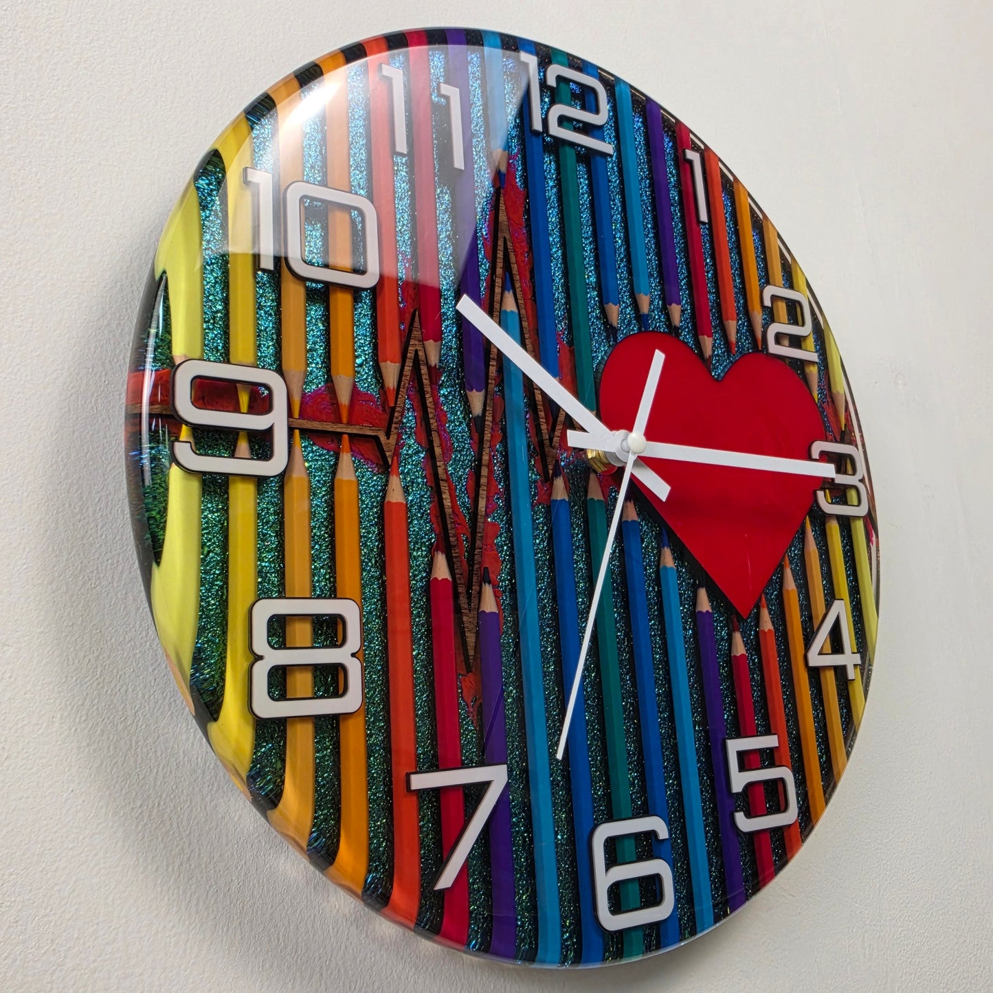 Contemporary handcrafted resin clock inspired by art, creativity, and emotion, featuring colorful pencils, a heartbeat line, and premium white acrylic numbers. V2