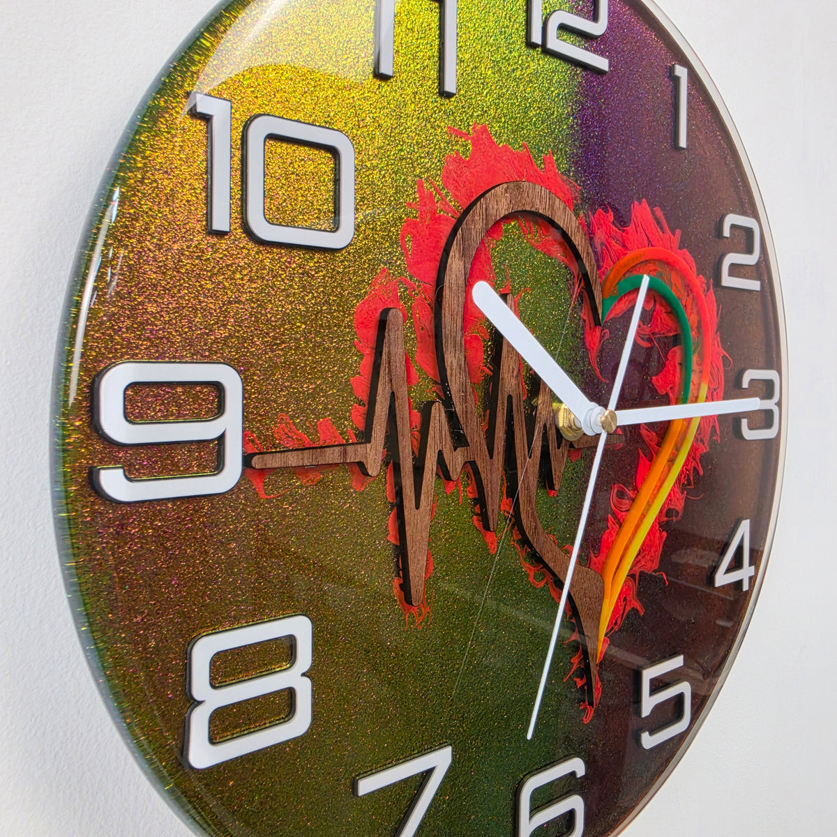 Unique artistic wall clock featuring a black walnut heartbeat design encapsulated in clear resin with chameleon colors.