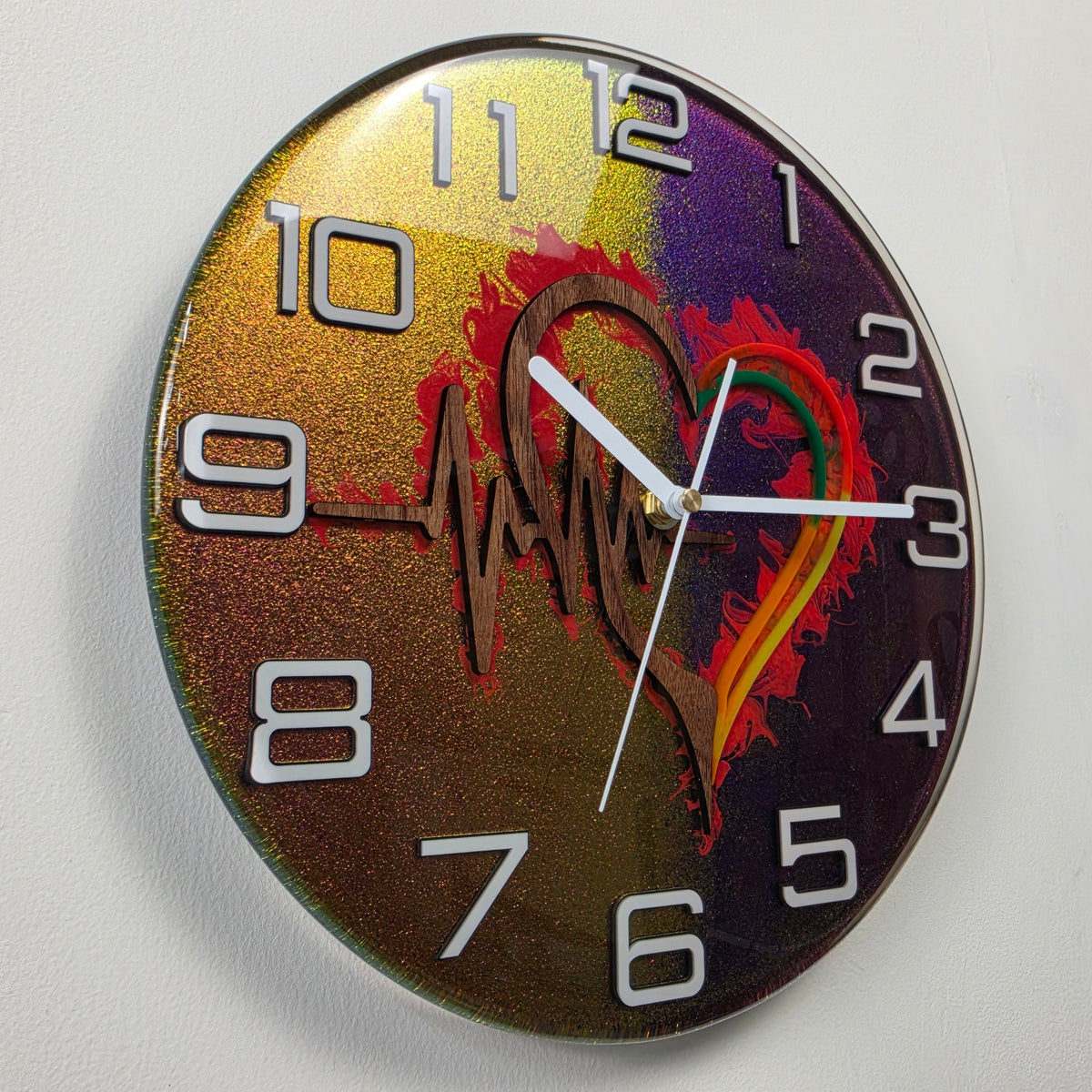 Close view of Heartbeat Within wall clock showing layered black walnut details and vibrant chameleon colors beneath clear resin.