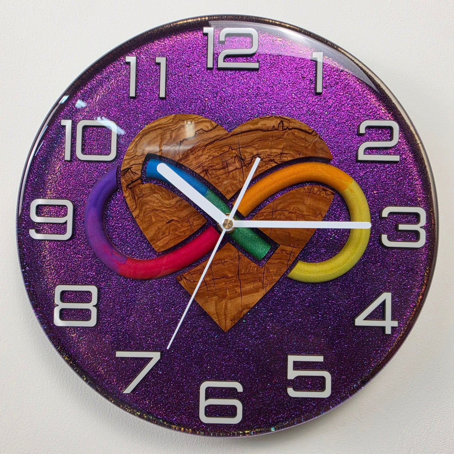 One-of-a-kind resin wall clock combining natural olive wood, colorful infinity artwork and a glossy chameleon finish.