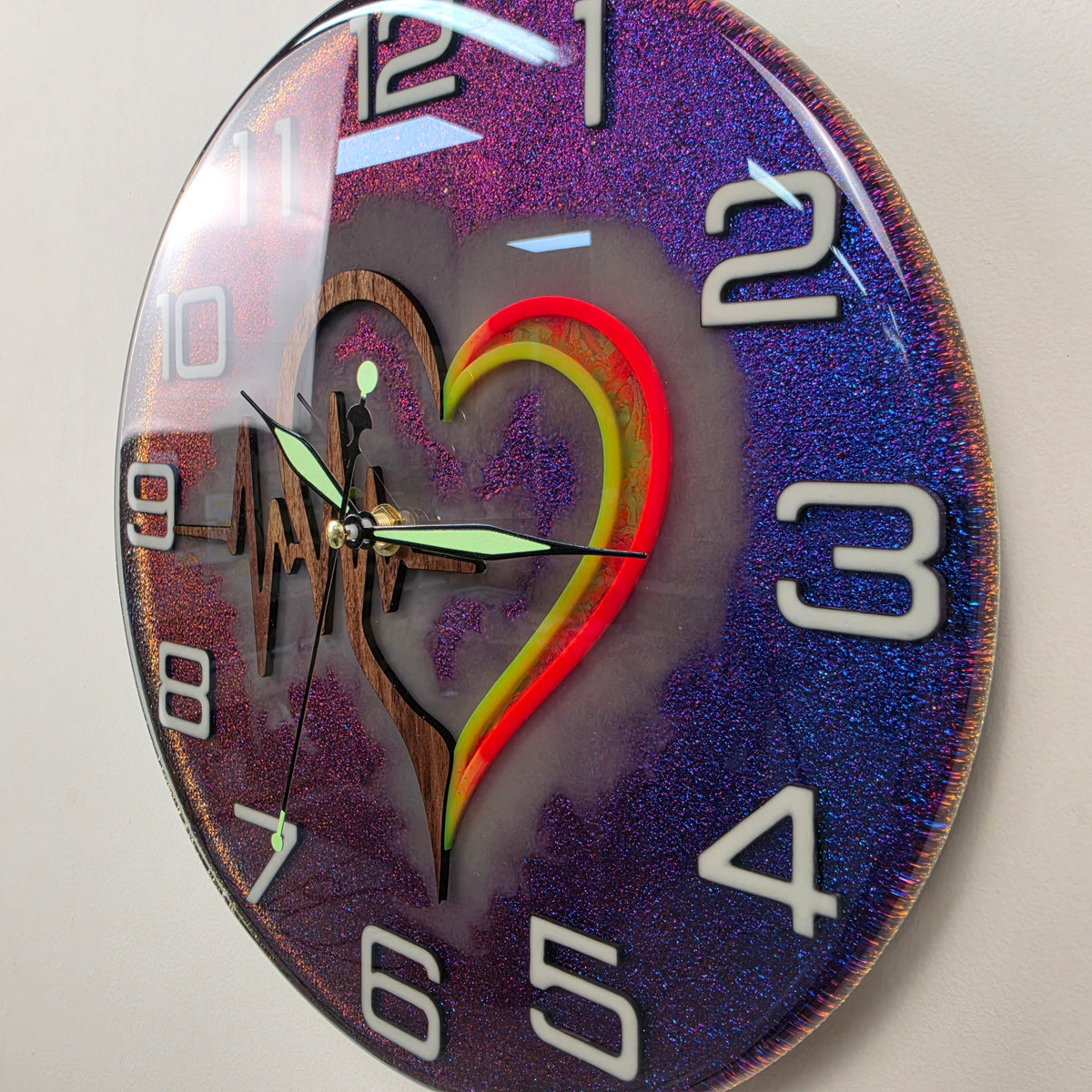 Handcrafted resin wall clock featuring a Black Walnut heart and heartbeat ECG design with colorful chameleon effect.