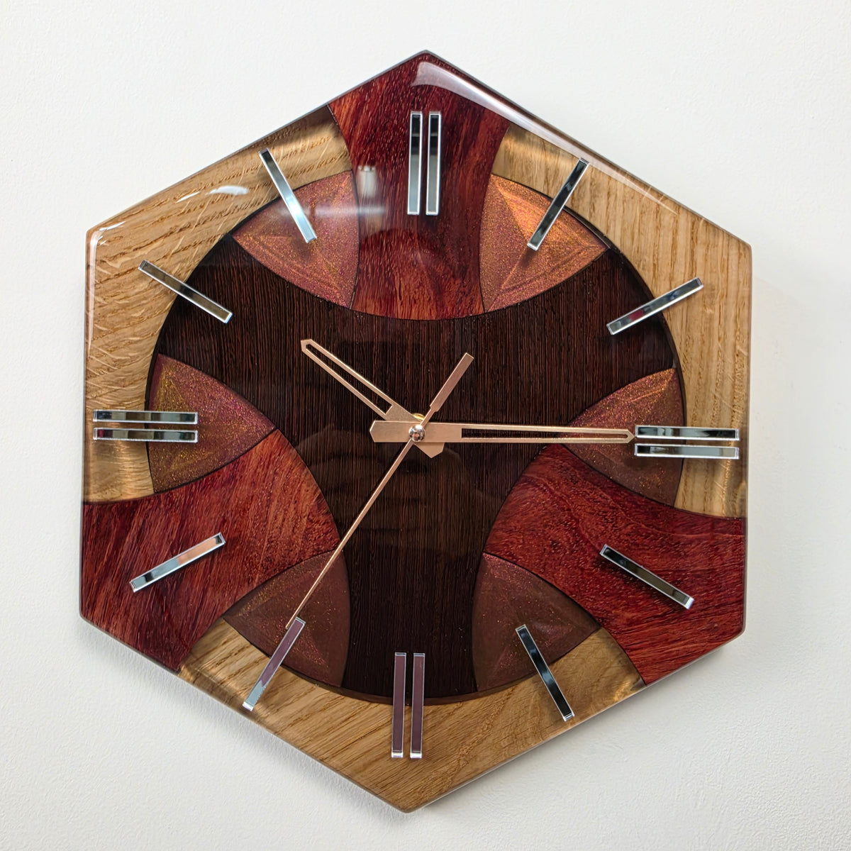 Unique handmade wood and resin wall clock with three natural woods, colorful accents and mirrored Plexiglas hour markers.