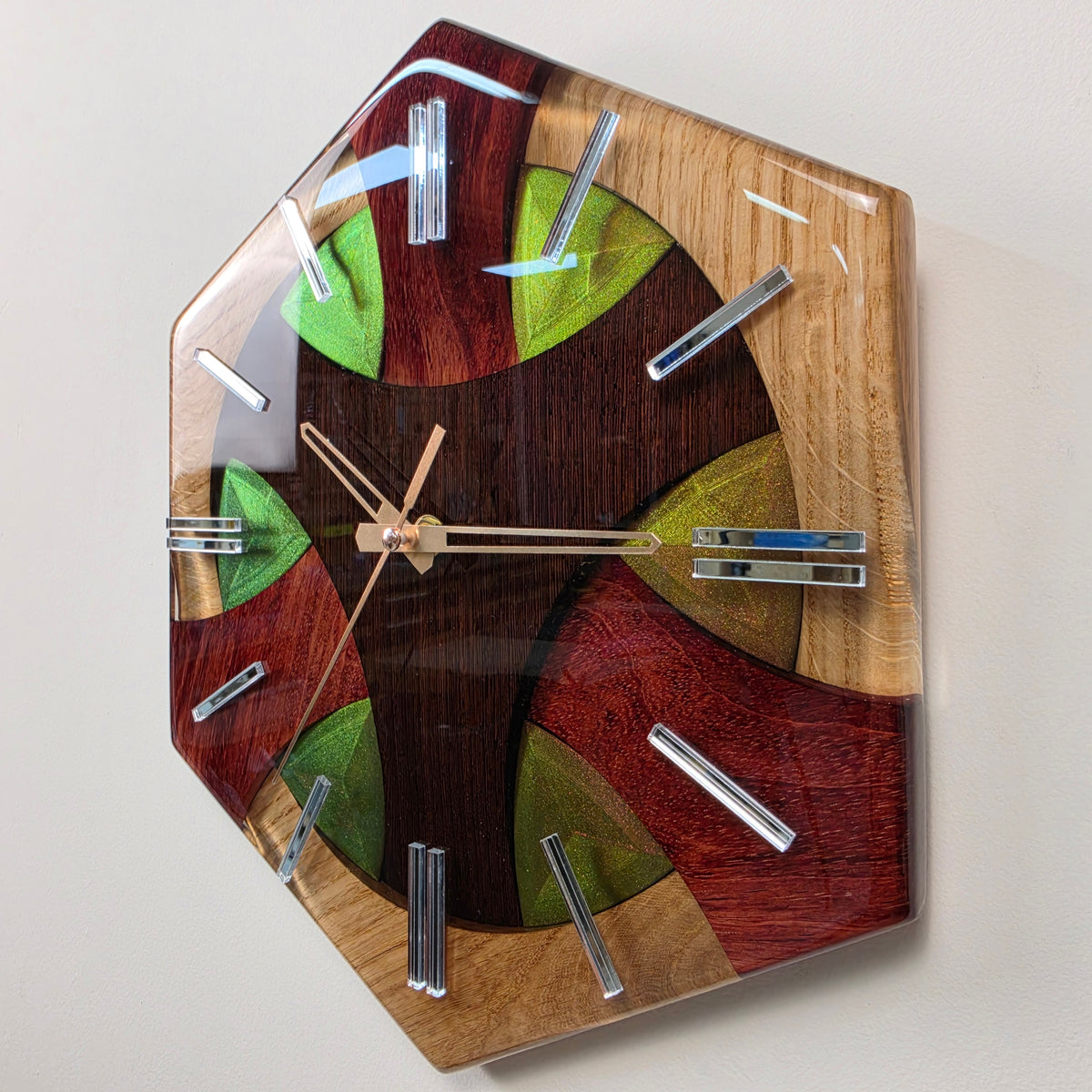 Geometric 30 x 30 cm wall clock combining oak, wenge and bubinga wood in a high-gloss transparent resin finish.