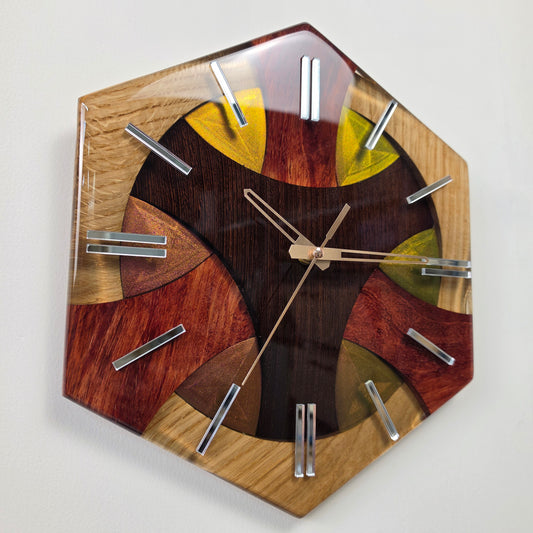 Handmade geometric wall clock crafted from oak, wenge and bubinga wood with transparent resin and mirrored hour markers.