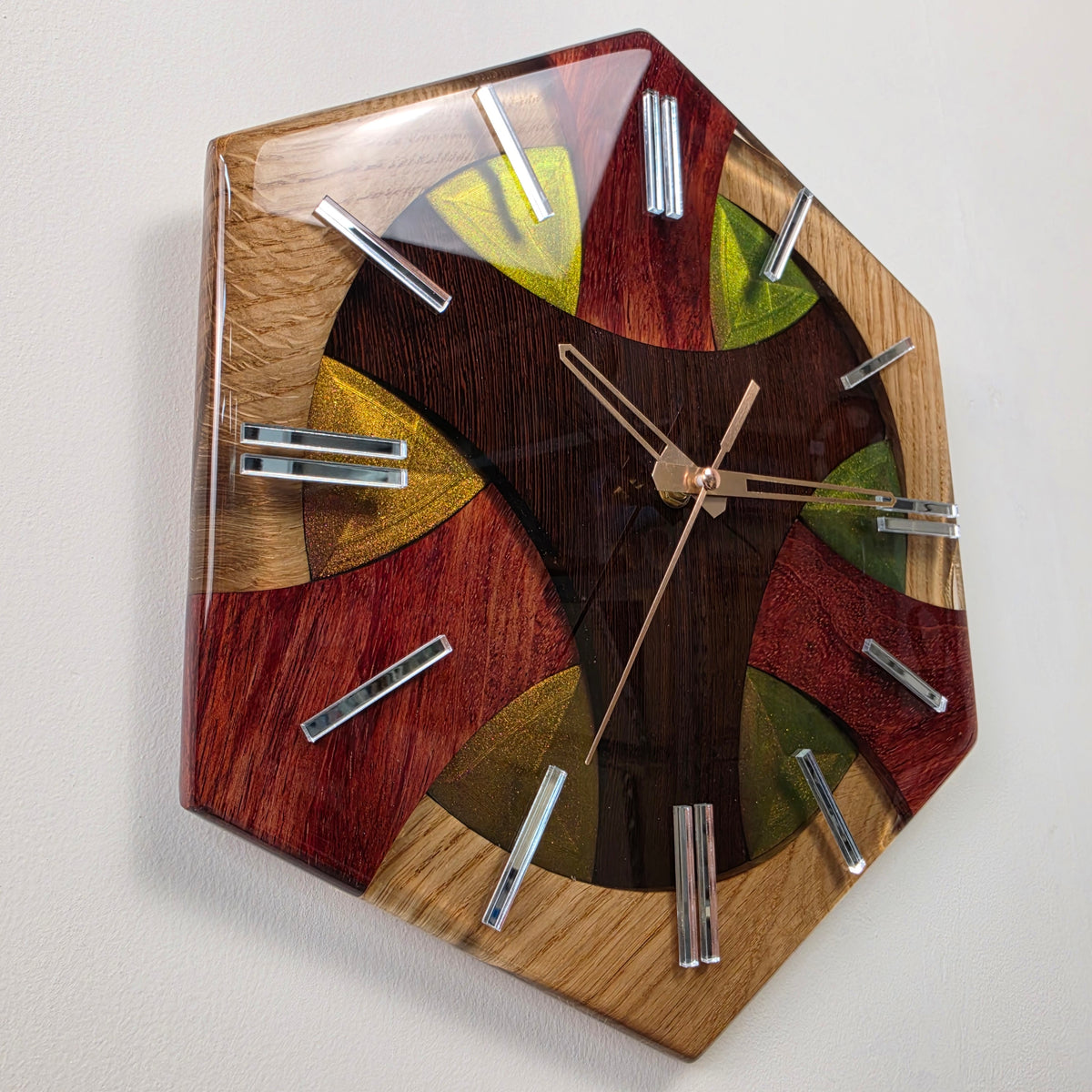 Modern handcrafted wall clock with contrasting oak, wenge and bubinga arranged in a distinctive geometric composition.