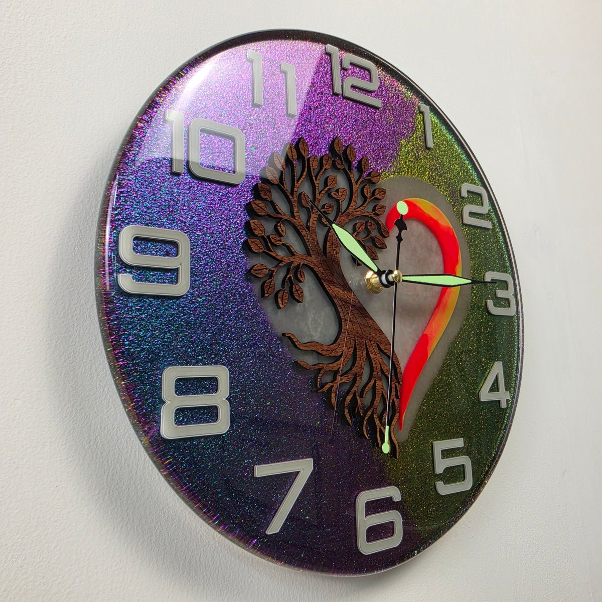 Glow-in-the-dark Tree of Life wall clock with luminous heart, glowing numerals and fluorescent clock hands.
