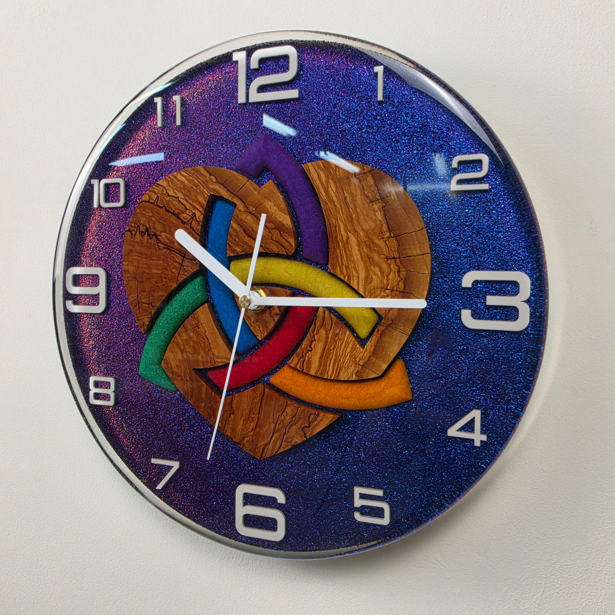 One-of-a-kind olive wood and resin wall clock featuring a symbolic woven heart and vibrant chameleon colors.
