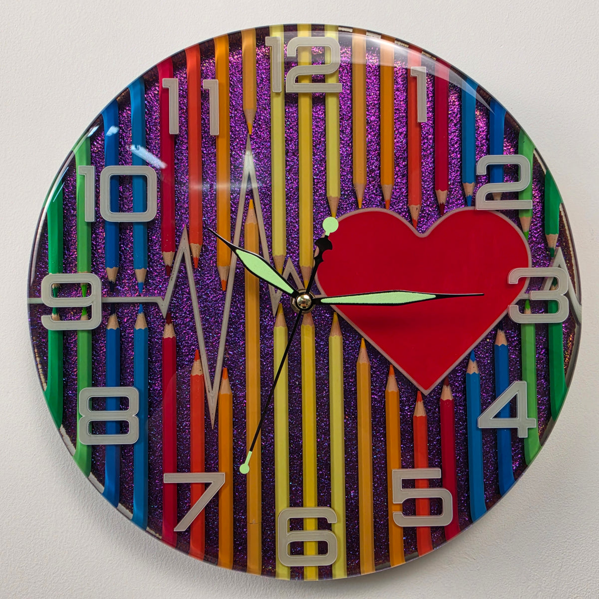 Modern artistic wall clock combining epoxy resin, colored pencils, red heart and ECG heartbeat design.