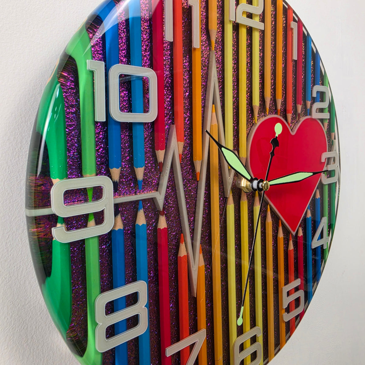Pulse of Imagination V3 artistic wall clock featuring colored pencils, a red heart, ECG line and chameleon resin background.