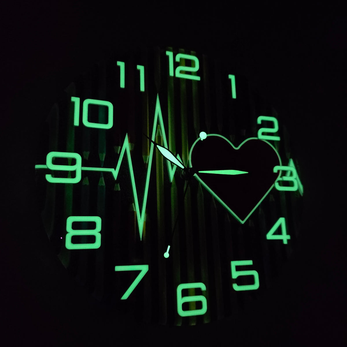 Glow-in-the-dark resin wall clock with luminous numbers, hands and heartbeat line surrounding a red heart.