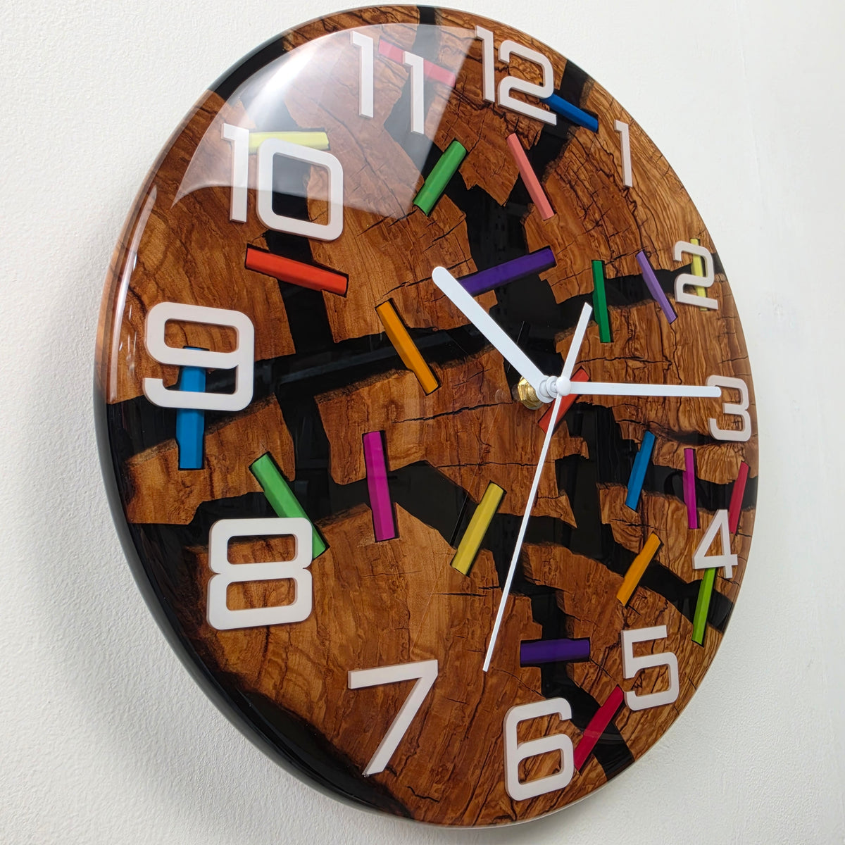 Close-up of cracked olive wood and colorful pencil pieces encapsulated beneath transparent epoxy resin.