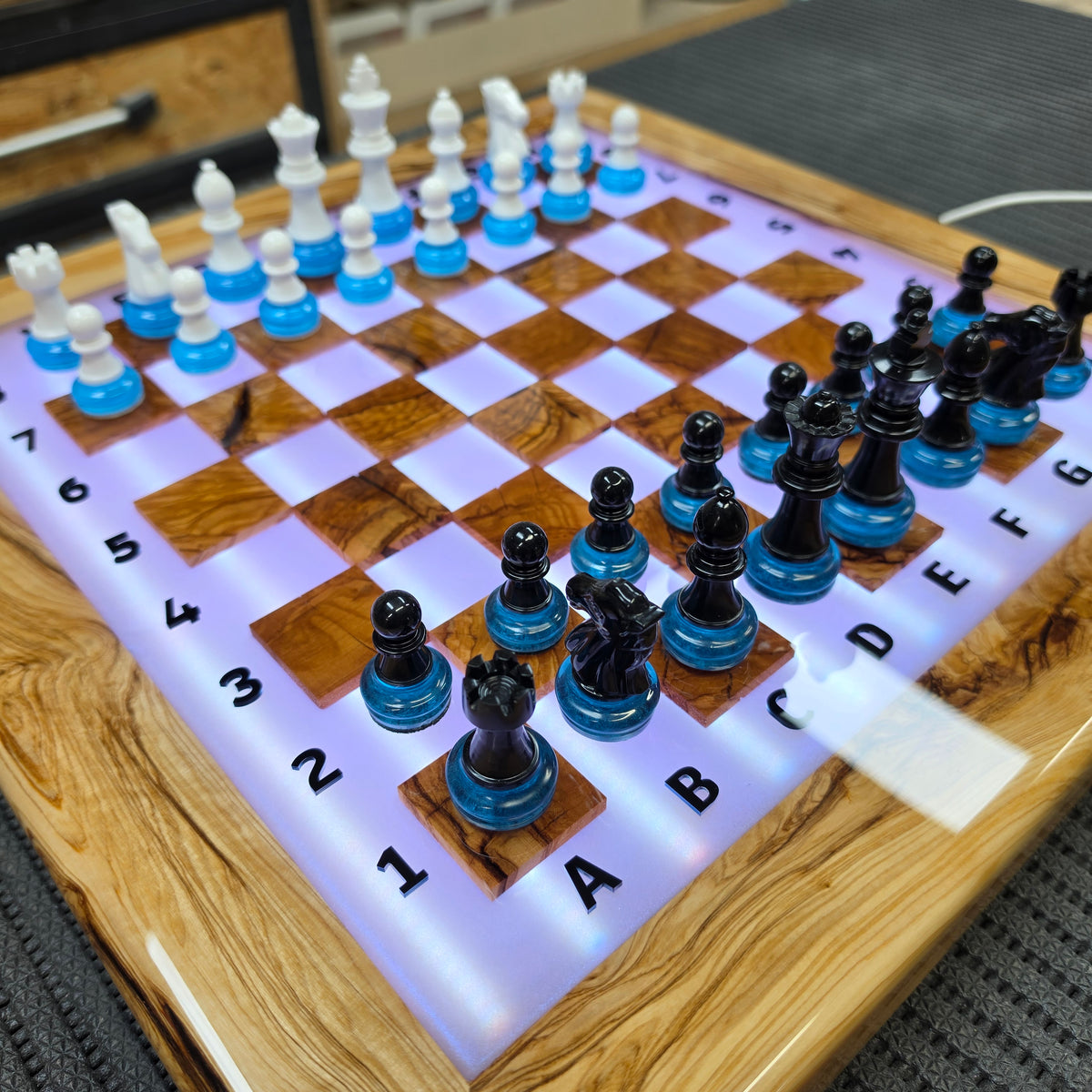 Olive wood chessboard with glowing resin squares and handmade chess pieces