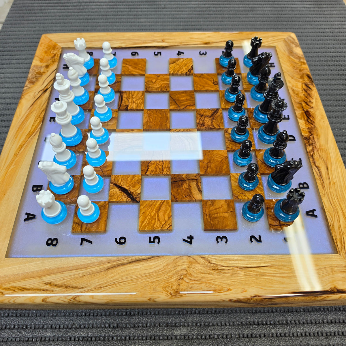 Glowing handmade chessboard with olive wood, epoxy resin and blue LED light