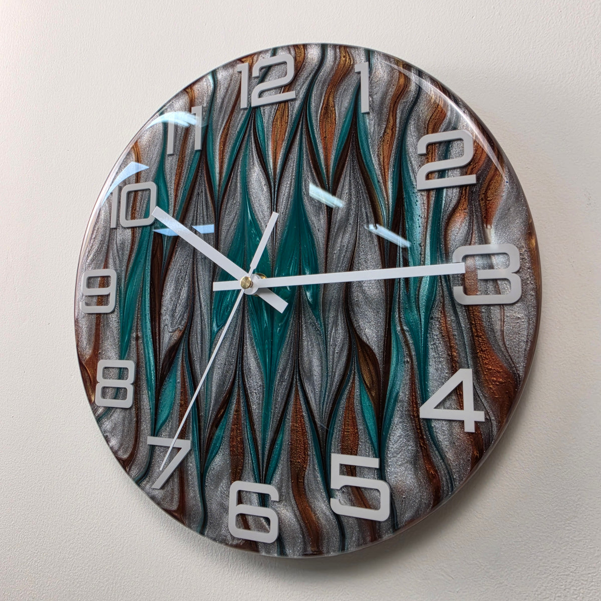 Handcrafted abstract wall clock featuring intertwined turquoise and silver waves with rich copper accents.
