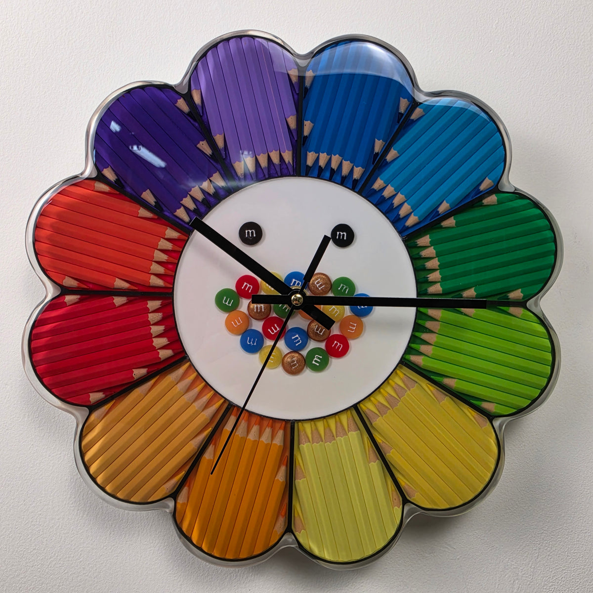 Close-up of real colored pencils in purple, blue, green, yellow, orange and red forming colorful flower petals.