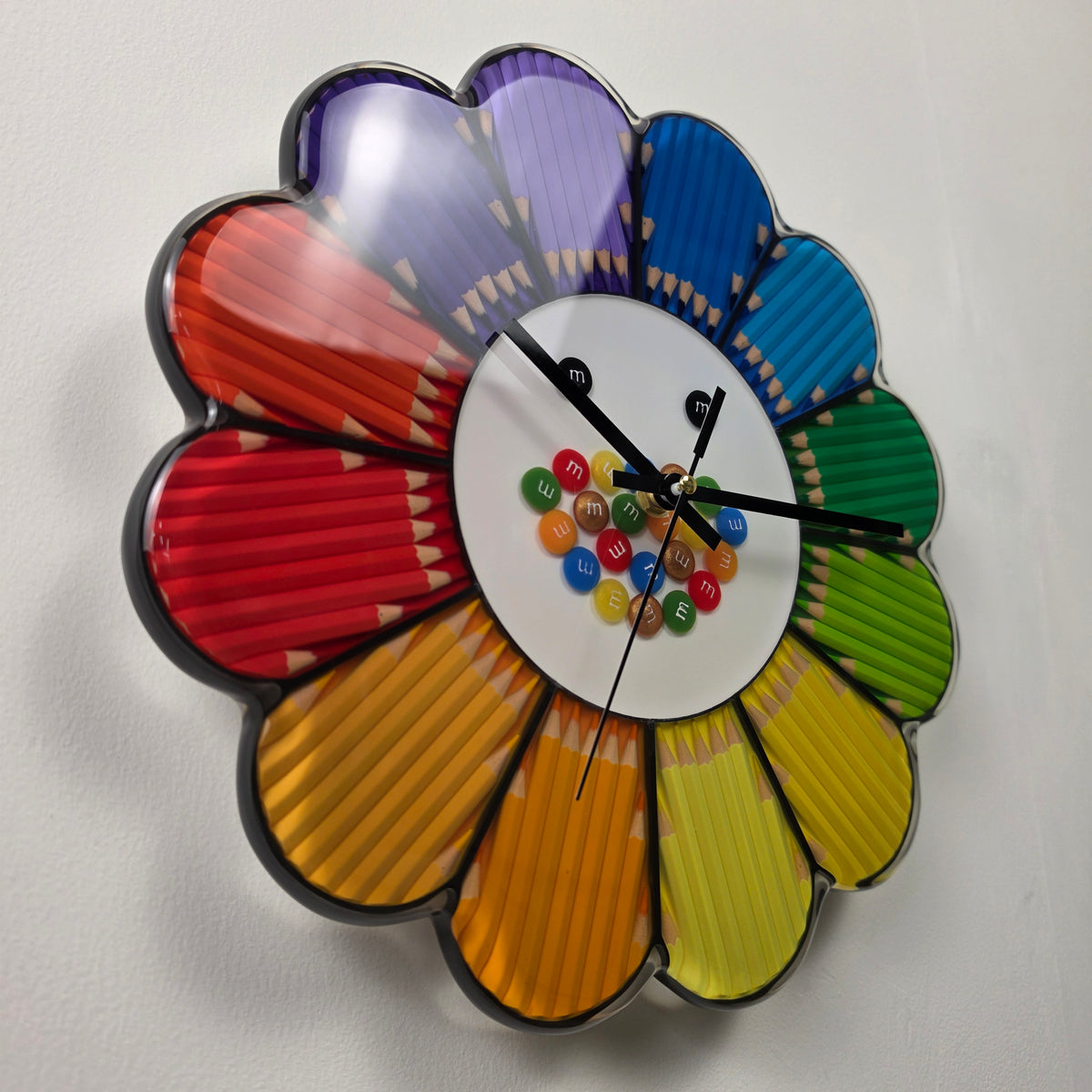 Detailed view of the white clock center decorated with colorful M&M-inspired resin candy casts and playful black eyes.