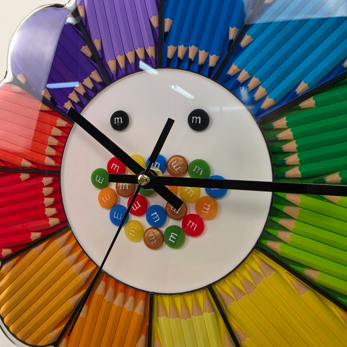 Angled view of Rainbow Bloom showing its glossy transparent resin finish and three-dimensional pencil arrangement.