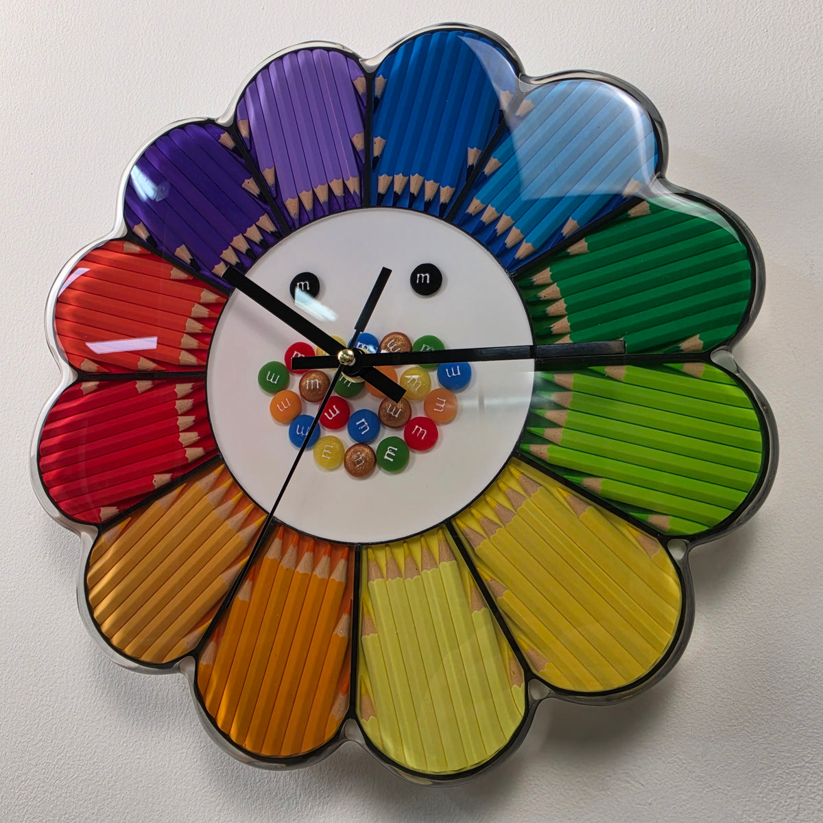 Front view of a 30 cm handmade resin wall clock with vibrant colored pencils arranged in a flower design.