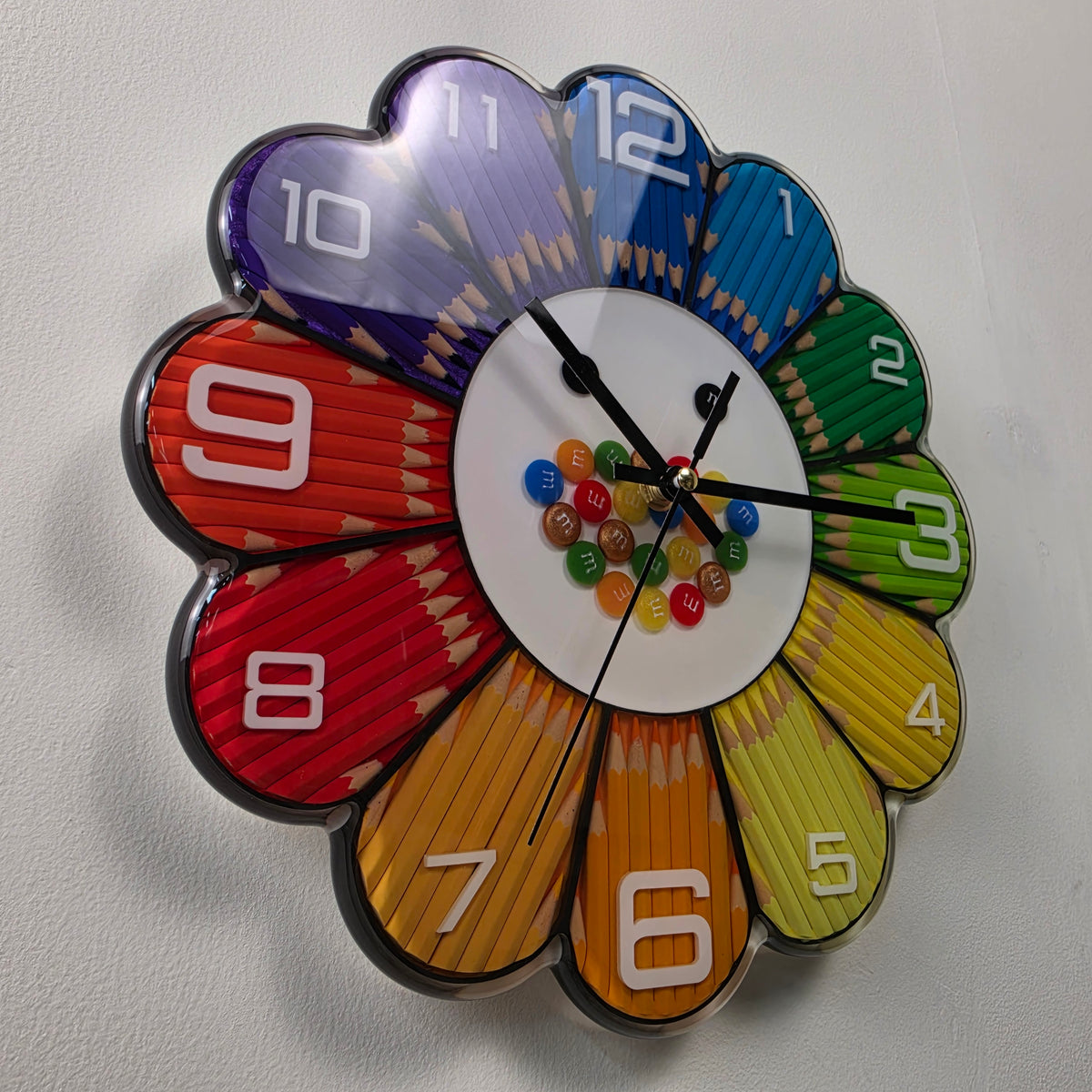 Front view of a 30 cm handmade resin wall clock with real colored pencils arranged in a vibrant rainbow flower design.