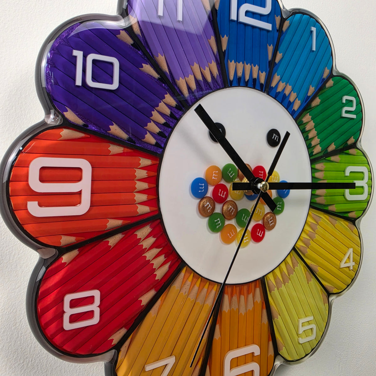 Unique handmade Italian wall clock combining real colored pencils, decorative resin candies and modern white hour numbers.