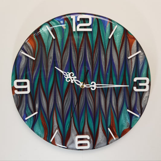 Front view of the “Aurora Stream” epoxy resin wall clock – round design with shimmering turquoise, navy, silver, and copper tones, and white plexiglass numbers.
