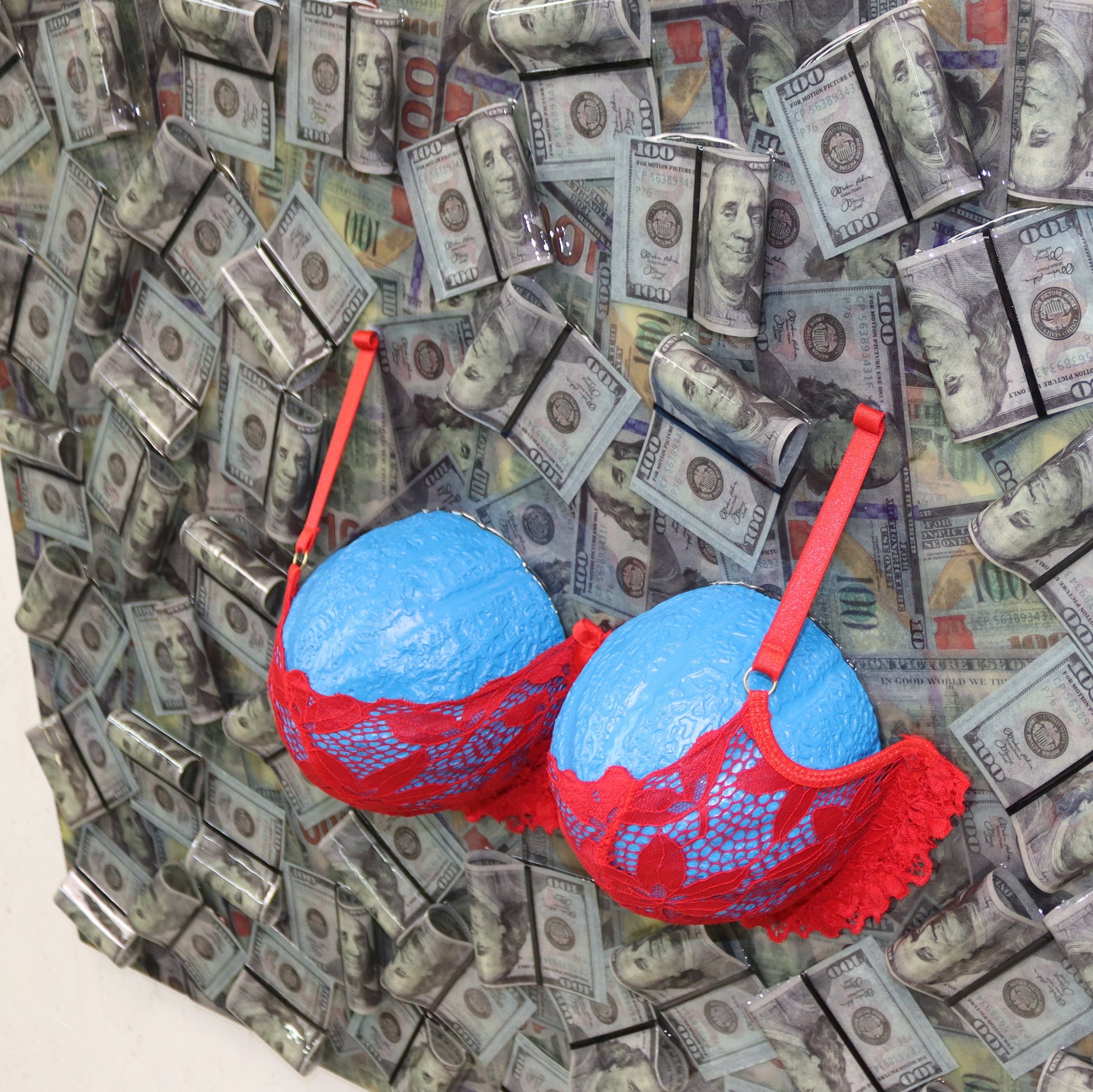 Mondo Blu contemporary conceptual art – large resin and plaster installation with dollar bills and red bra, displayed in interior