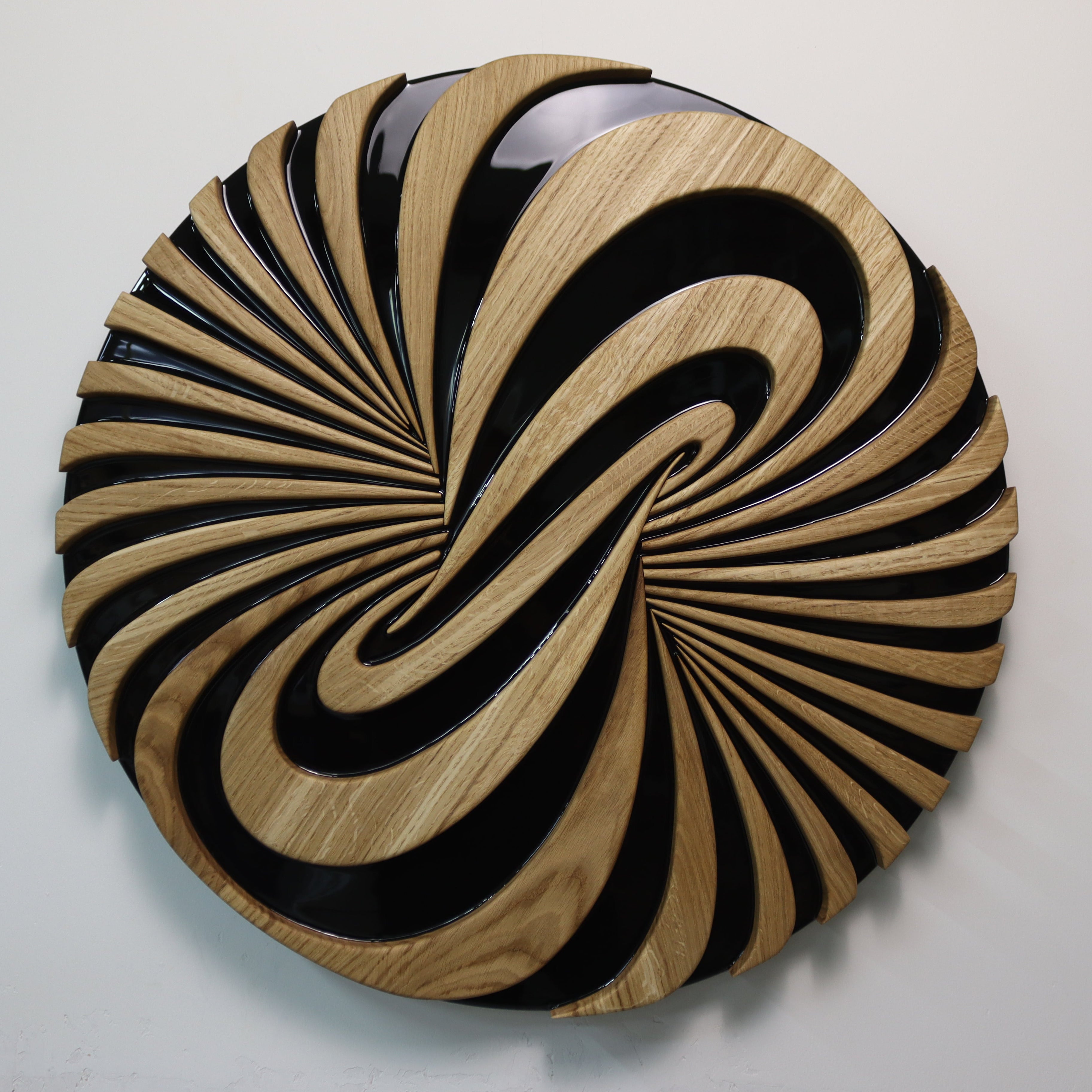 Detail of carved oak elements and black resin contrast in Vortice sculpture