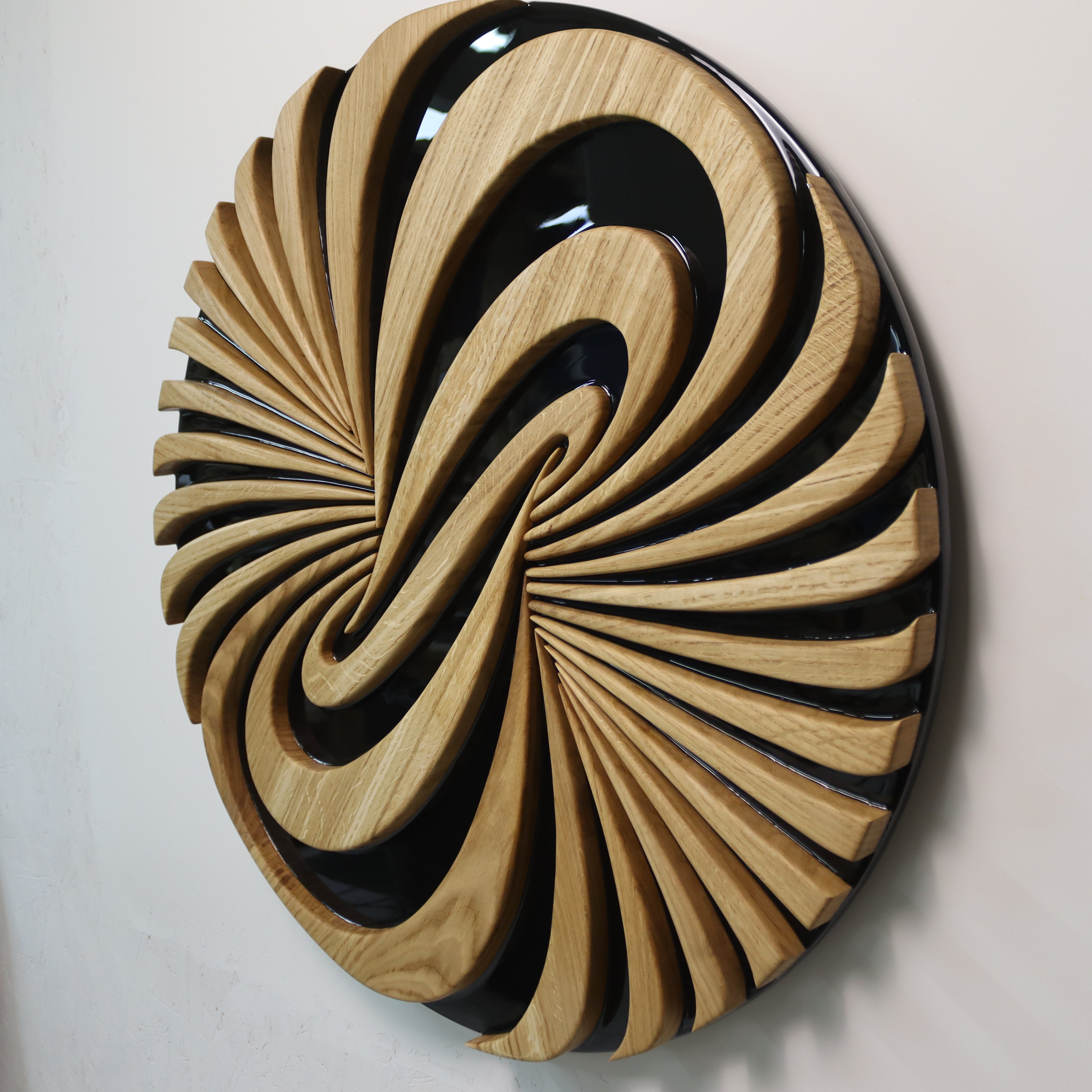 Angled view of Vortice sculpture showing depth and layered carved wood structure