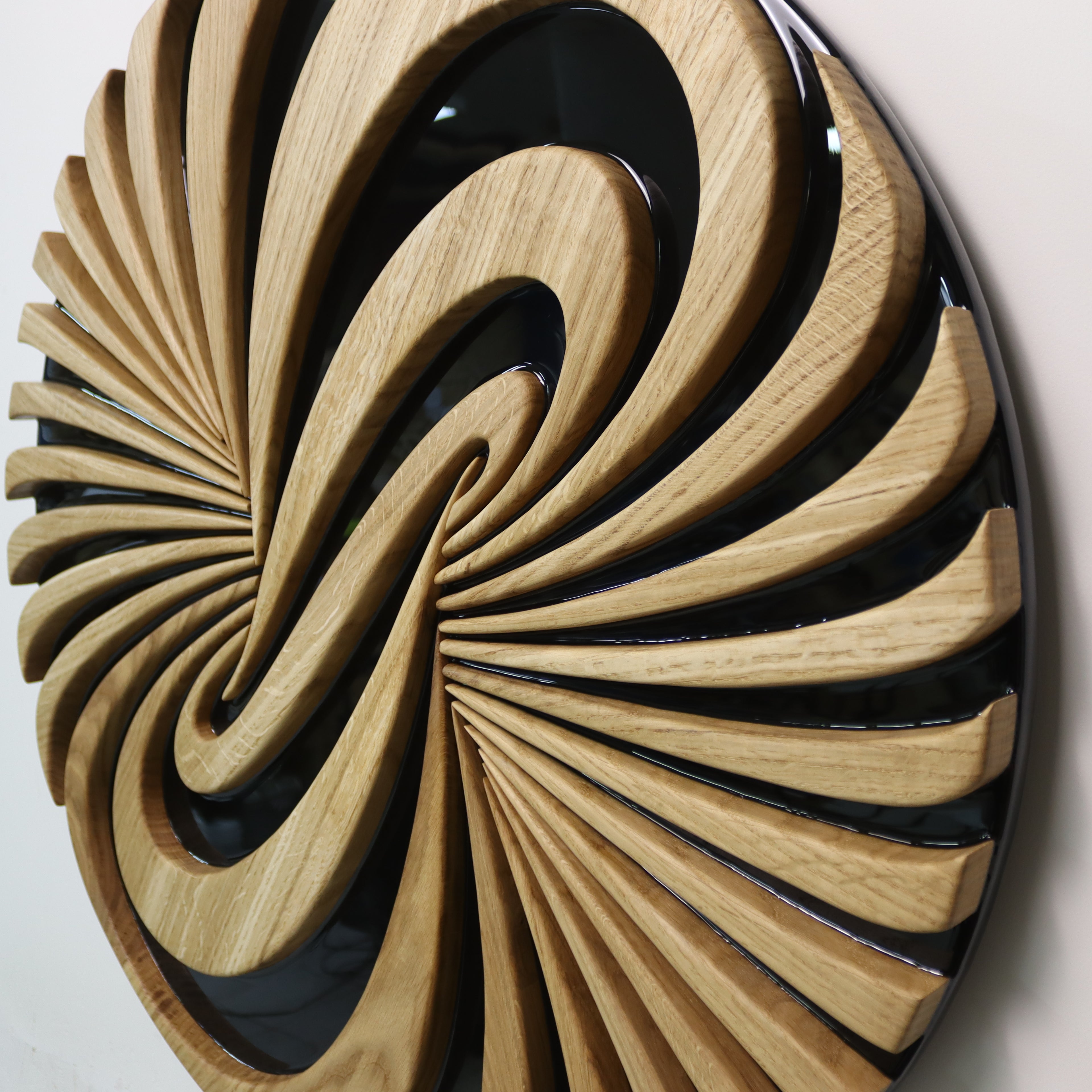 Close-up of Vortice sculpture, carved oak spiral with glossy black resin details