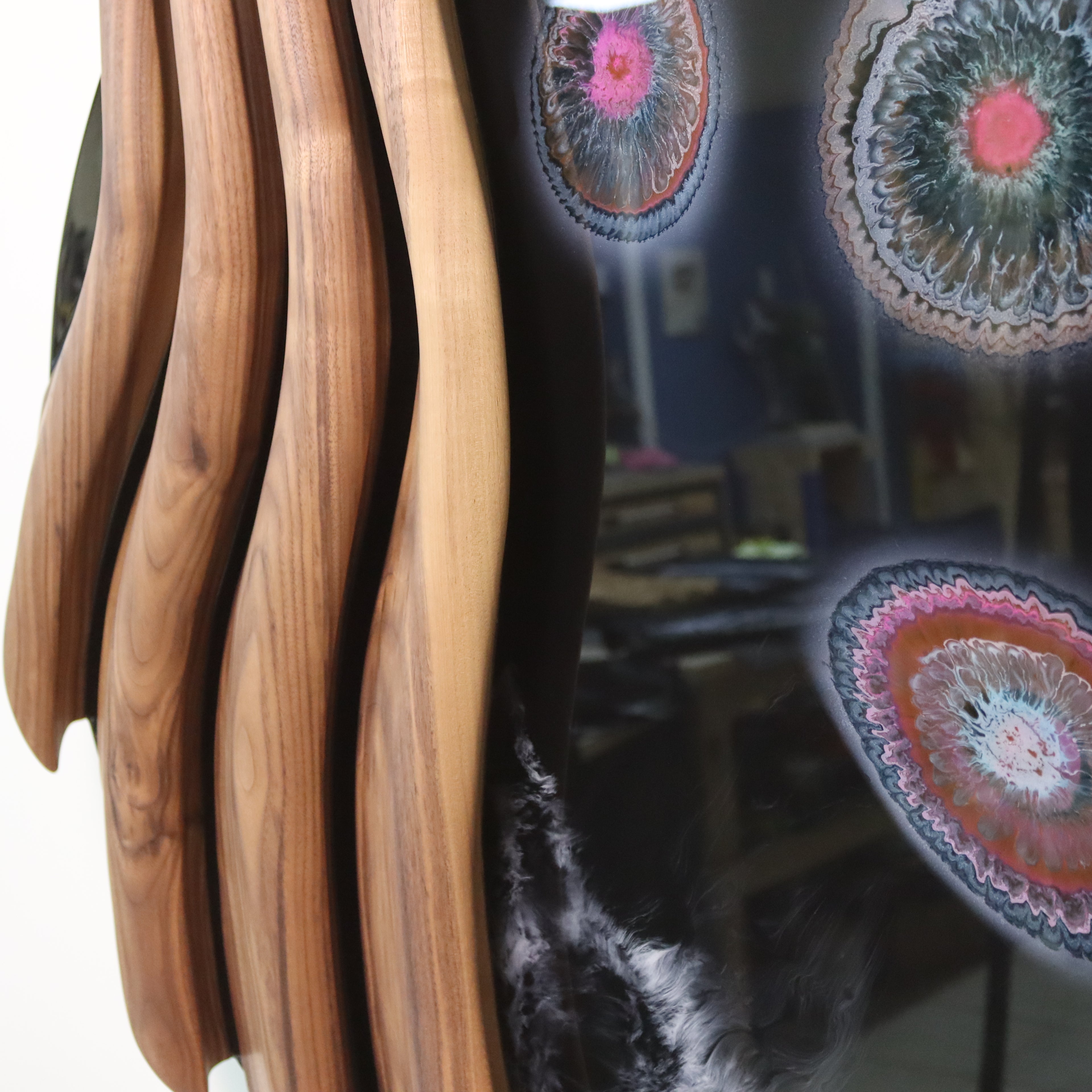 Close-up of hand-carved black walnut waves with glossy black resin