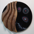 Black walnut and epoxy resin wall sculpture displayed in a modern living room