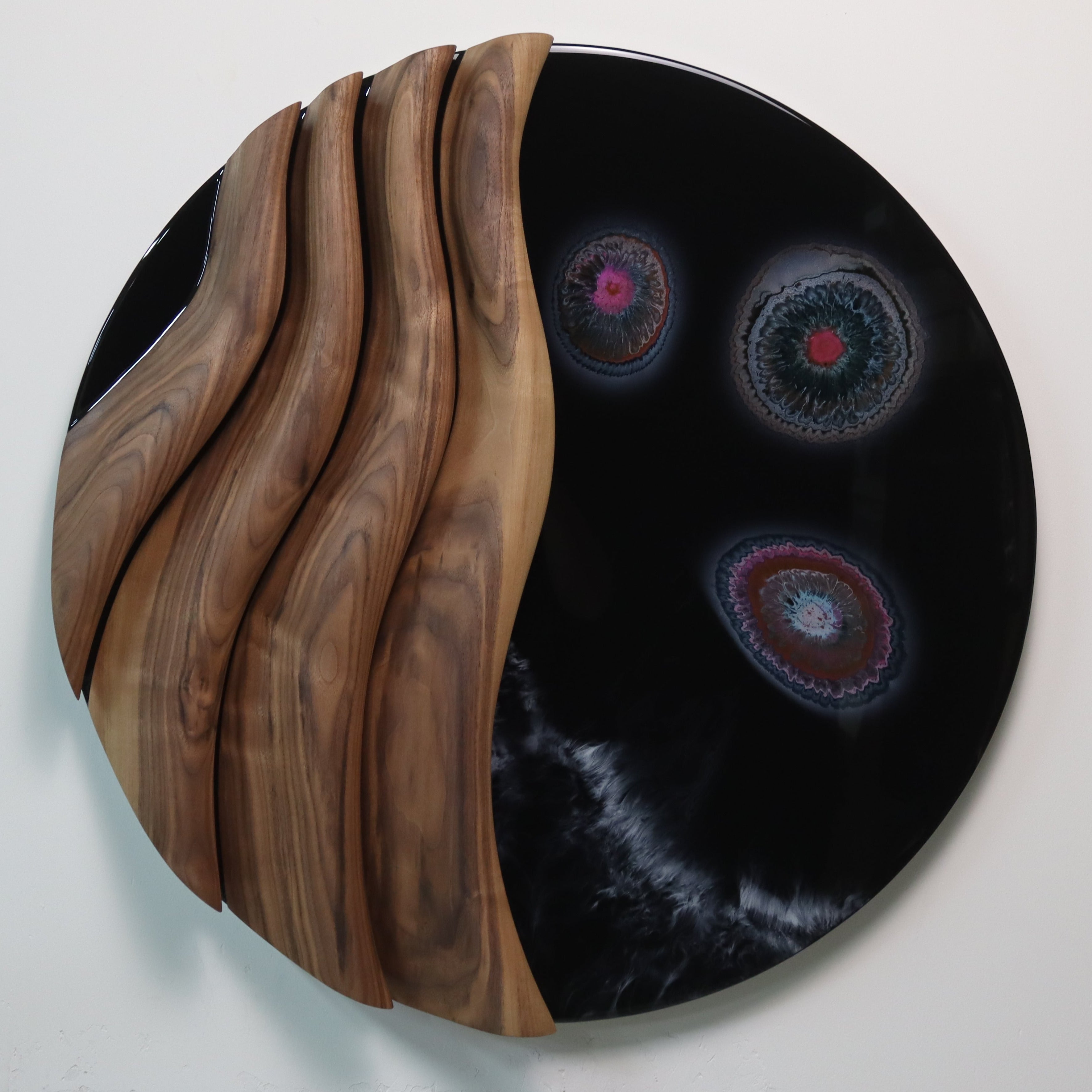 Black walnut and epoxy resin wall sculpture displayed in a modern living room