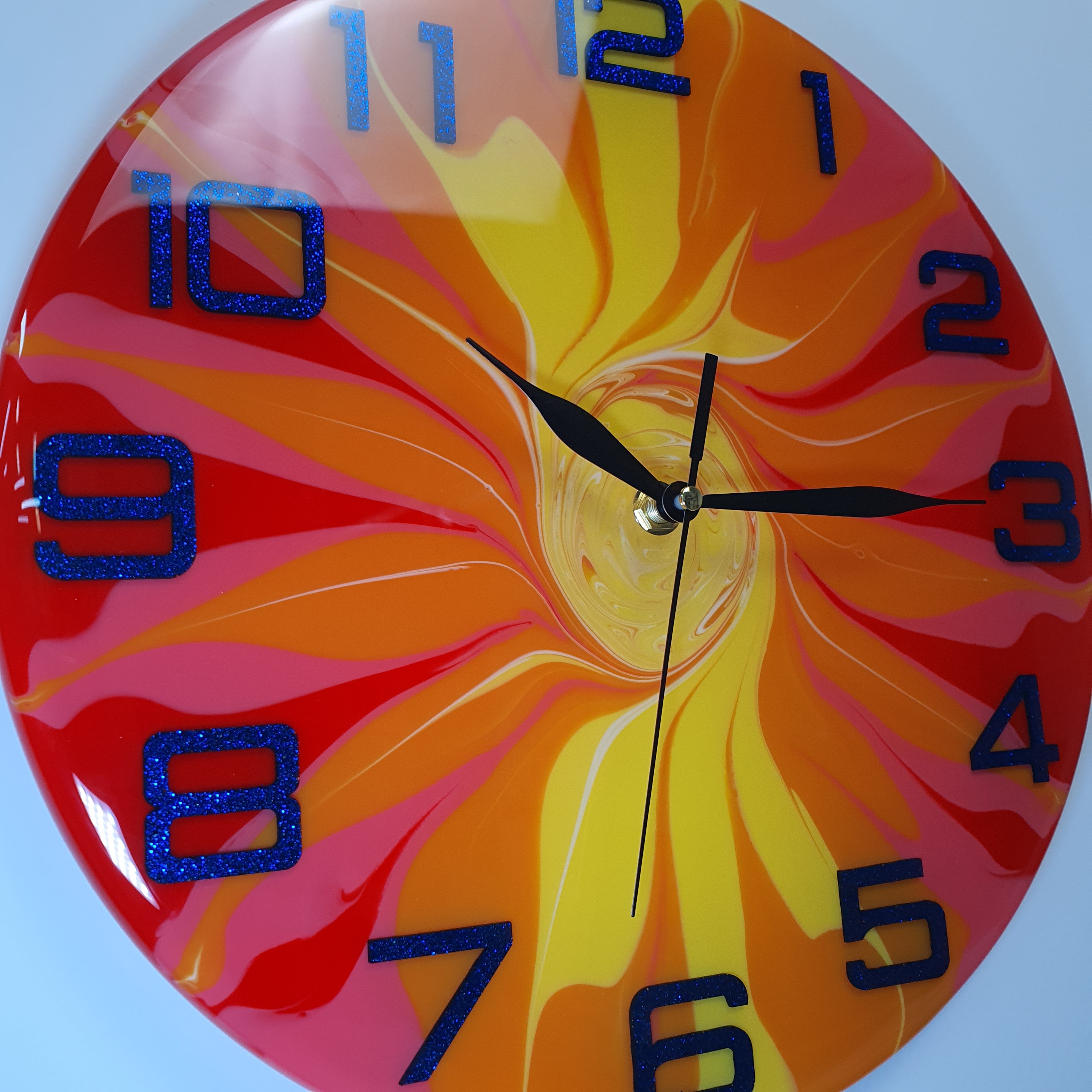 Close-up of the "Fire Bloom" clock face – glossy surface and vibrant flame-like color details